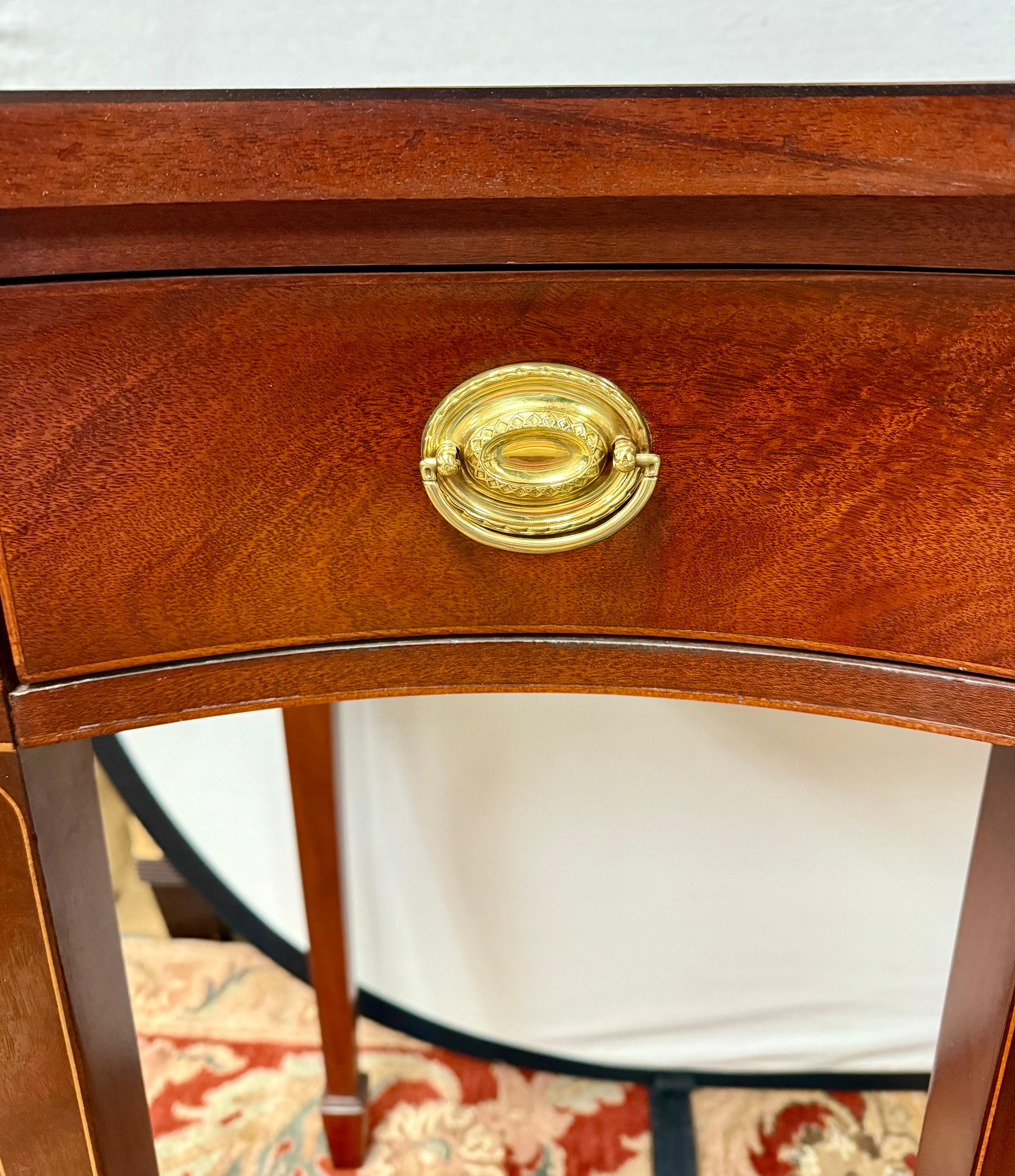 Baker Furniture Historic Charleston Federal inlaid mahogany console table showcases the finest craftsmanship with intricate oval and line inlay and brass hardware.  A versatile piece for your dining or living room as well as a study or foyer.  It's