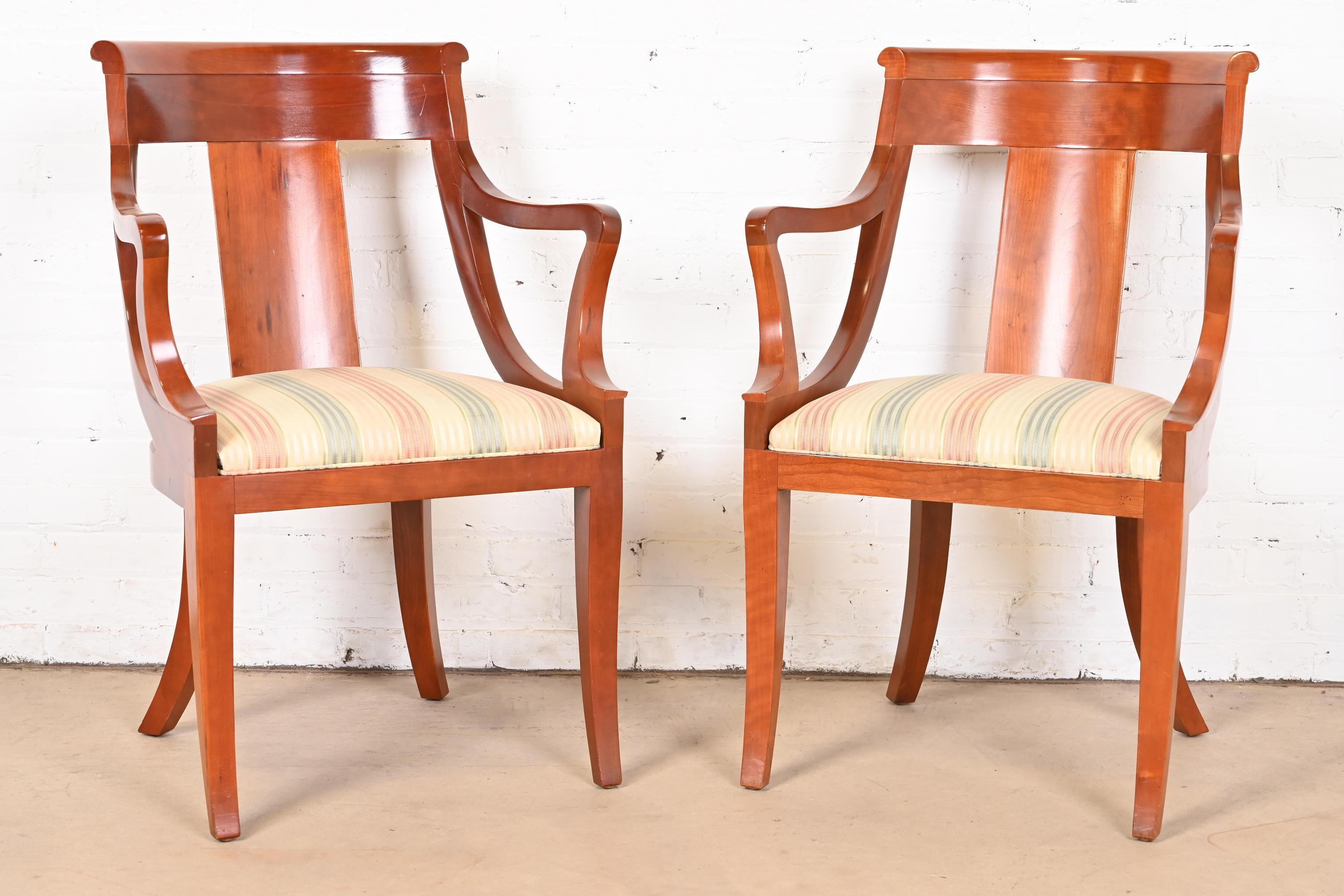 An outstanding pair of Regency style armchairs or dining captain chairs

By Baker Furniture

USA, Circa 1980s

Solid cherry wood frames, with upholstered seats.

Measures: 23.25