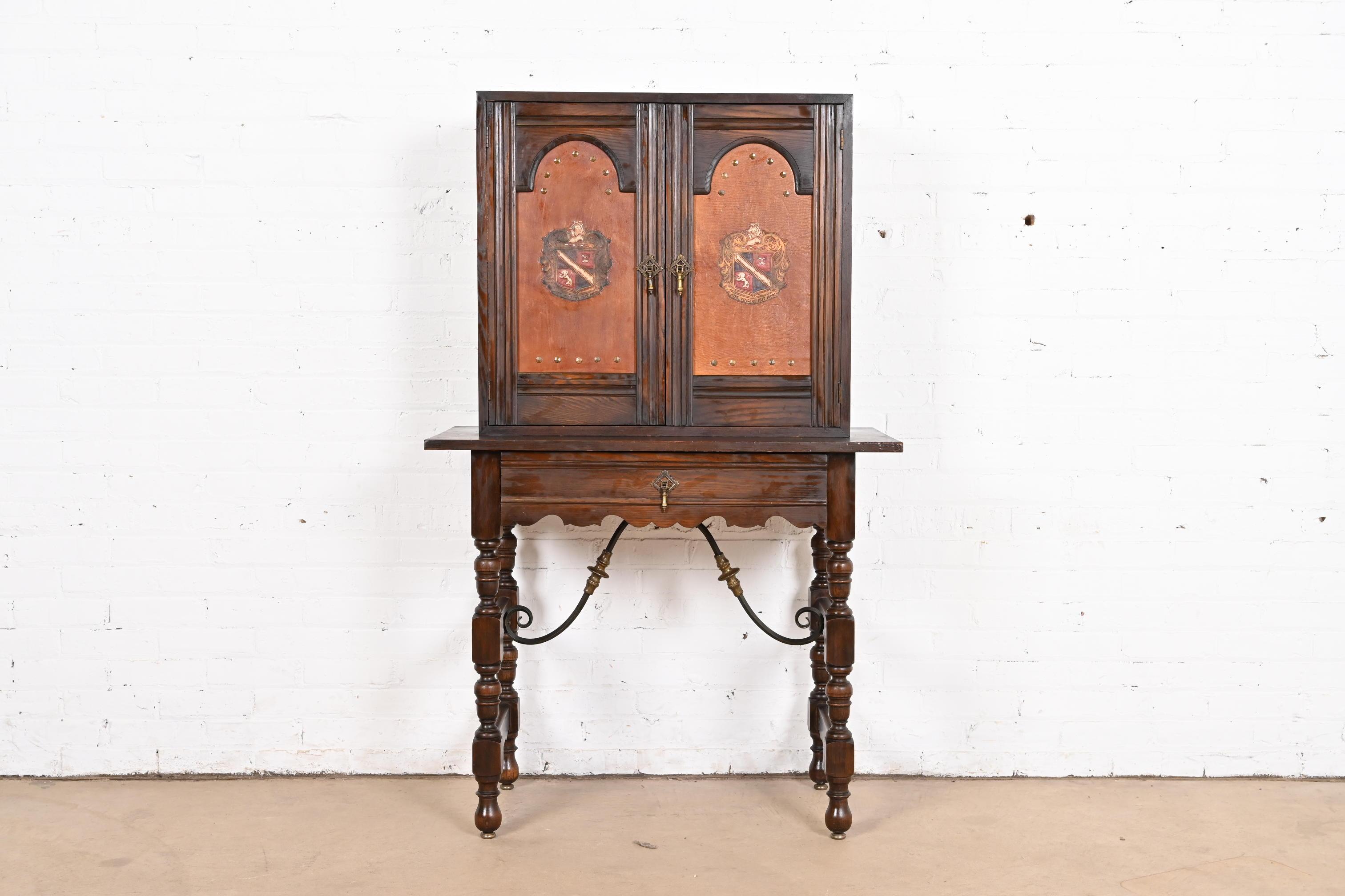 An exceptional Spanish Colonial or English Jacobean style bookcase, china hutch, or bar cabinet

By Baker Furniture (marked with early label)

USA, Early 20th Century

Carved oak, with embossed leather front, iron and brass stretchers, and original
