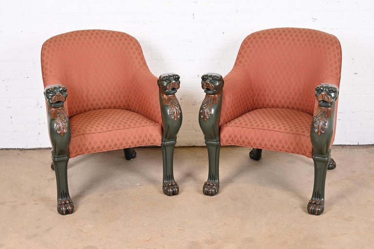 An outstanding pair of Regency upholstered tub chairs in the Egyptian style decorated in deep vert-de-bronze green and gilt. Elaborately hand-carved leopard masks continuing into lifelike clawed and padded feet. Giltwood manes and other decorated