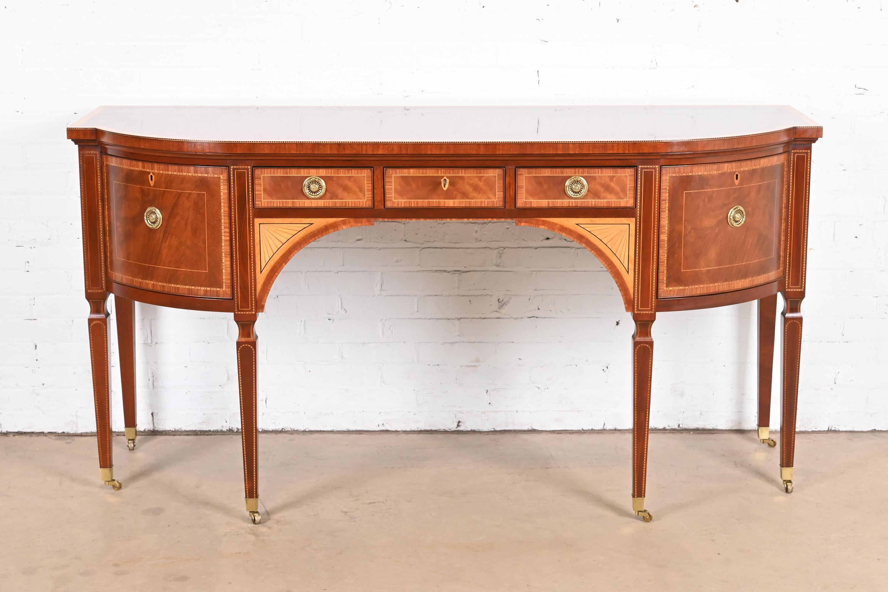 A rare and exceptional Sheraton or Hepplewhite style bow front sideboard or credenza

From the exclusive Stately Homes Collection by Baker Furniture

USA, Circa 1980s

Gorgeous flame mahogany, with satinwood inlay, original brass hardware, and