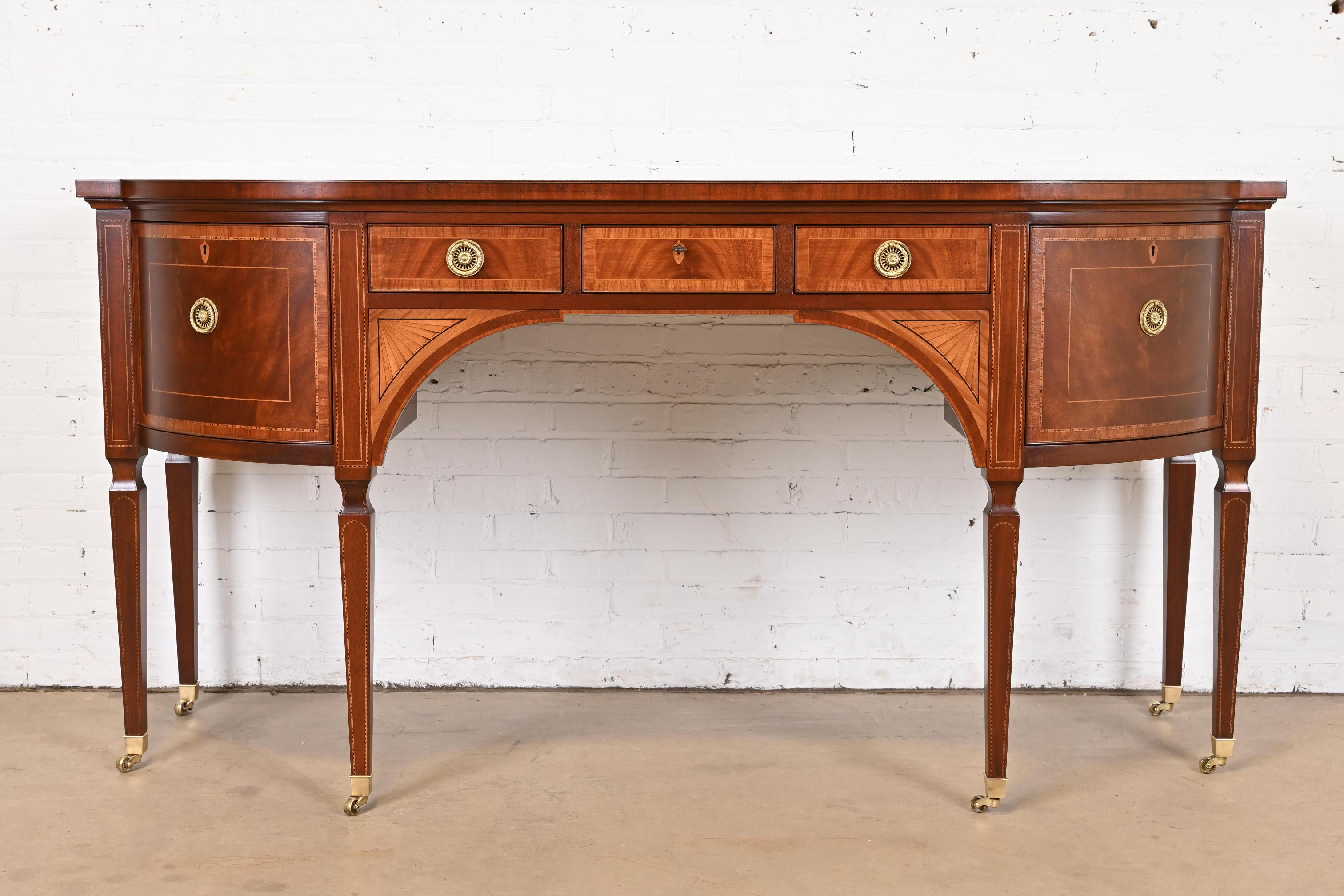 A rare and exceptional Sheraton or Hepplewhite style bow front sideboard or credenza

From the exclusive Stately Homes Collection by Baker Furniture

USA, Circa 1980s

Gorgeous flame mahogany, with satinwood inlay, original brass hardware, and