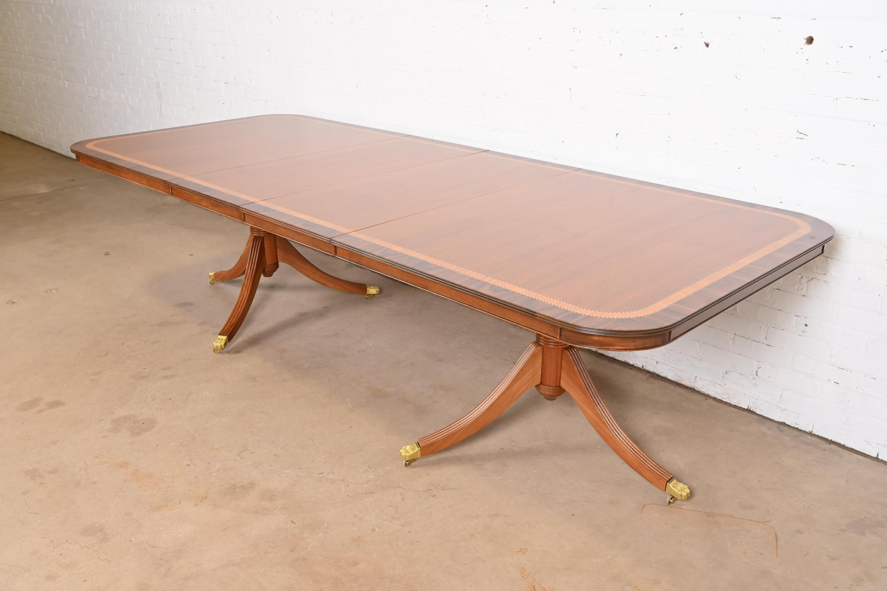 Exceptionnelle table à manger à rallonge à double piédestal de style Géorgien ou Régence.

À la manière des meubles Baker

Angleterre, fin du 20e siècle

Magnifique plateau en merisier, avec bandes de bois satiné et de noyer, piédestaux en merisier