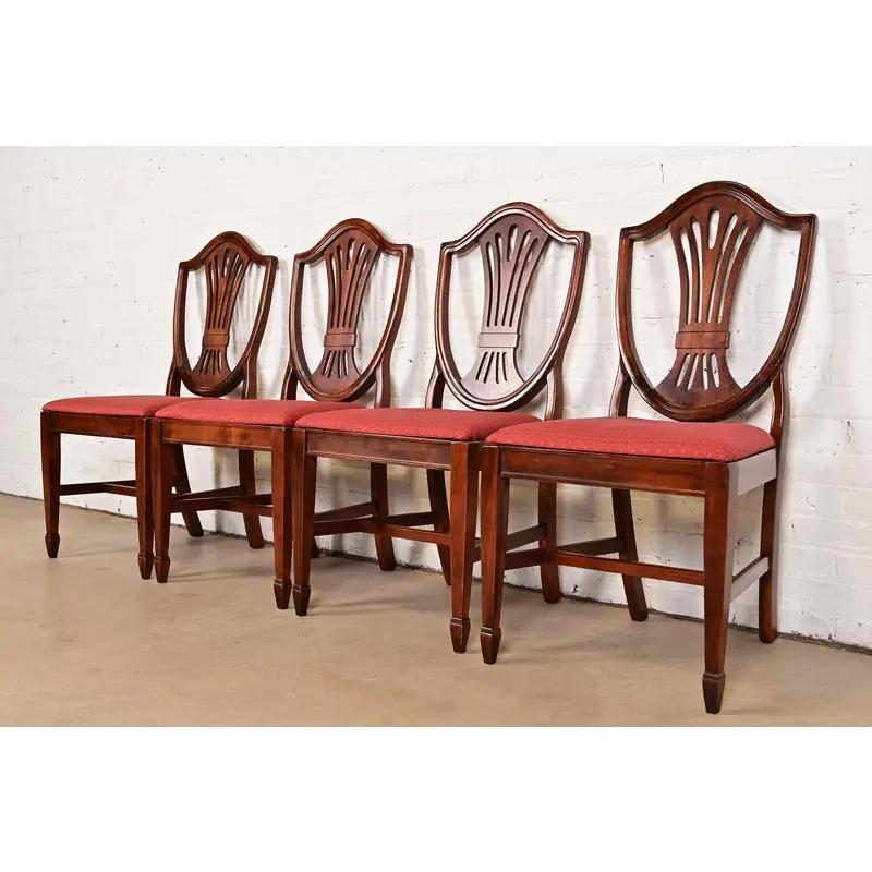 Uno splendido set di quattro sedie da pranzo con schienale a scudo in stile Feder o Hepplewhite

Alla maniera di Baker Furniture

Stati Uniti, fine del XX secolo

Struttura in mogano massiccio intagliato, con sedili imbottiti.

Misure: 19,75