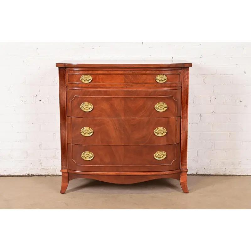 A gorgeous Federal or Georgian style bow front four-drawer dresser or chest of drawers

In the manner of Baker Furniture

USA, Circa 1980s

Carved mahogany, with original brass hardware.

Measures: 34