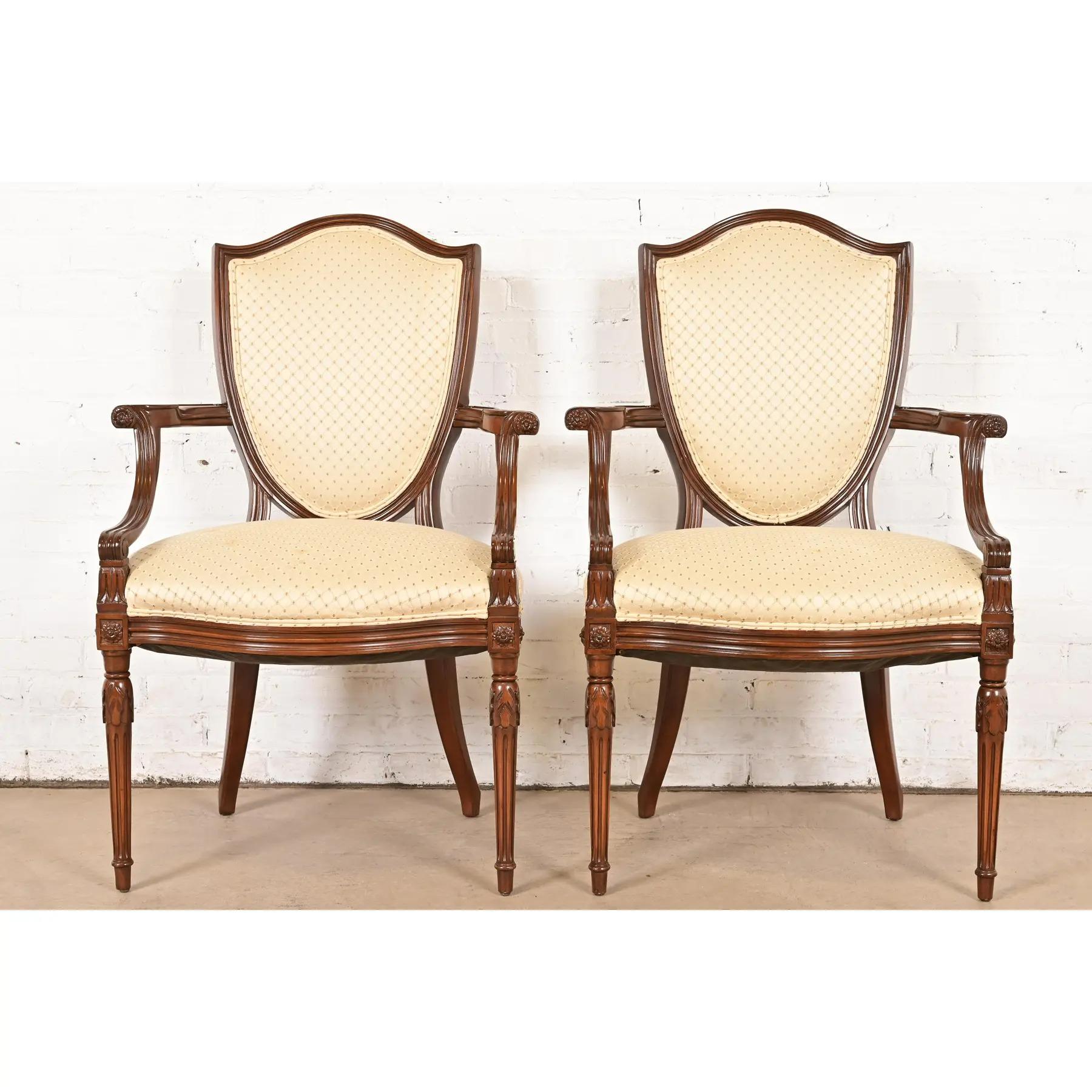 Una splendida coppia di poltrone con schienale a scudo in stile Reggenza francese Louis Shields o di sedie da pranzo per capitani

Alla maniera di Baker Furniture

Stati Uniti, circa fine XX secolo

Struttura in noce massiccio intagliato, con sedili