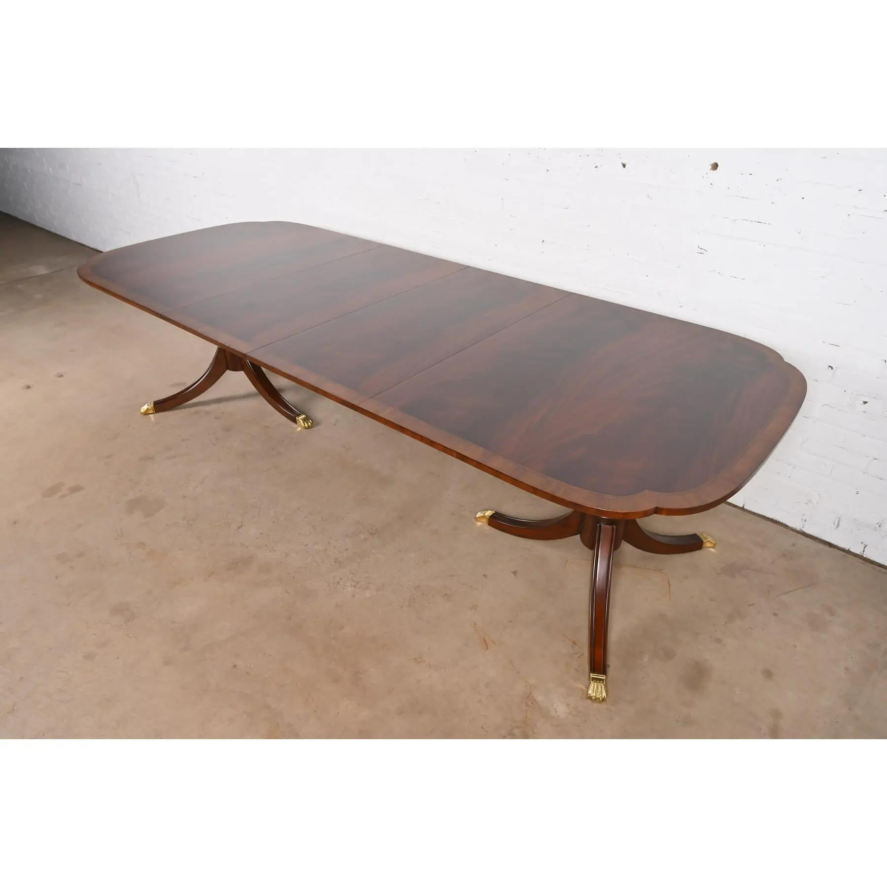 Ein außergewöhnlicher Doppel-Sockel-Esstisch im georgianischen oder Regency-Stil

Nach dem Vorbild von Baker Furniture

USA, ca. 1980er Jahre

Wunderschönes geflammtes Mahagoni, mit Satinholzbändern, geschnitzten Sockeln aus massivem Mahagoni und