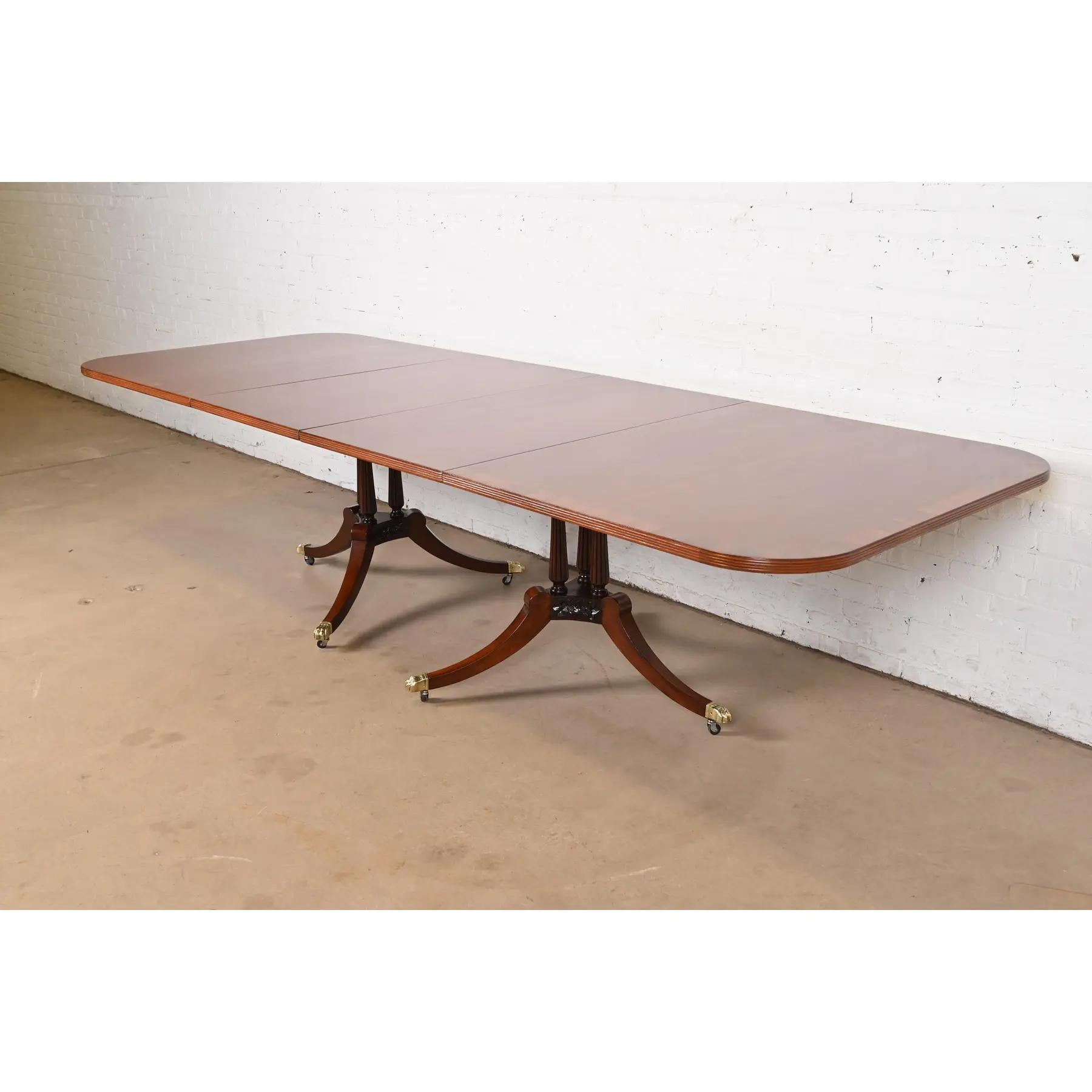Exceptionnelle table de salle à manger à double piédestal de style Régence ou Géorgien.

À la manière des meubles Baker

USA, Circa Mid-20th Century

Magnifique acajou, avec des bandes de bois de rose, des piédestaux en acajou sculpté et des pieds