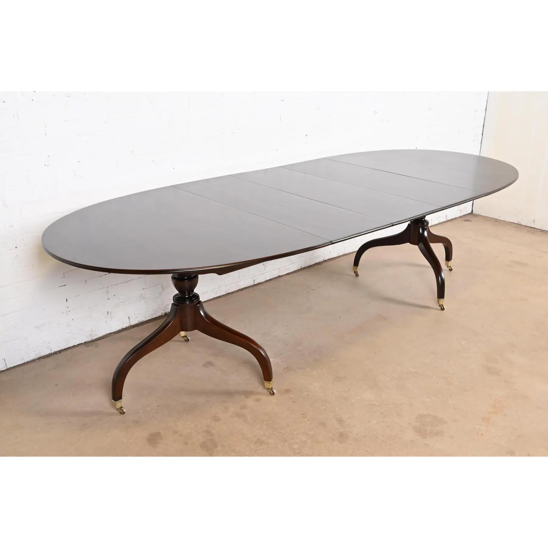 Ein außergewöhnlicher Doppel-Sockel-Esstisch im georgianischen oder Regency-Stil

Nach dem Vorbild von Baker Furniture

USA, ca. 1960er Jahre

Prächtige, gebänderte Mahagoniplatte mit geschnitzten Sockeln aus massivem Mahagoni und Füßen mit