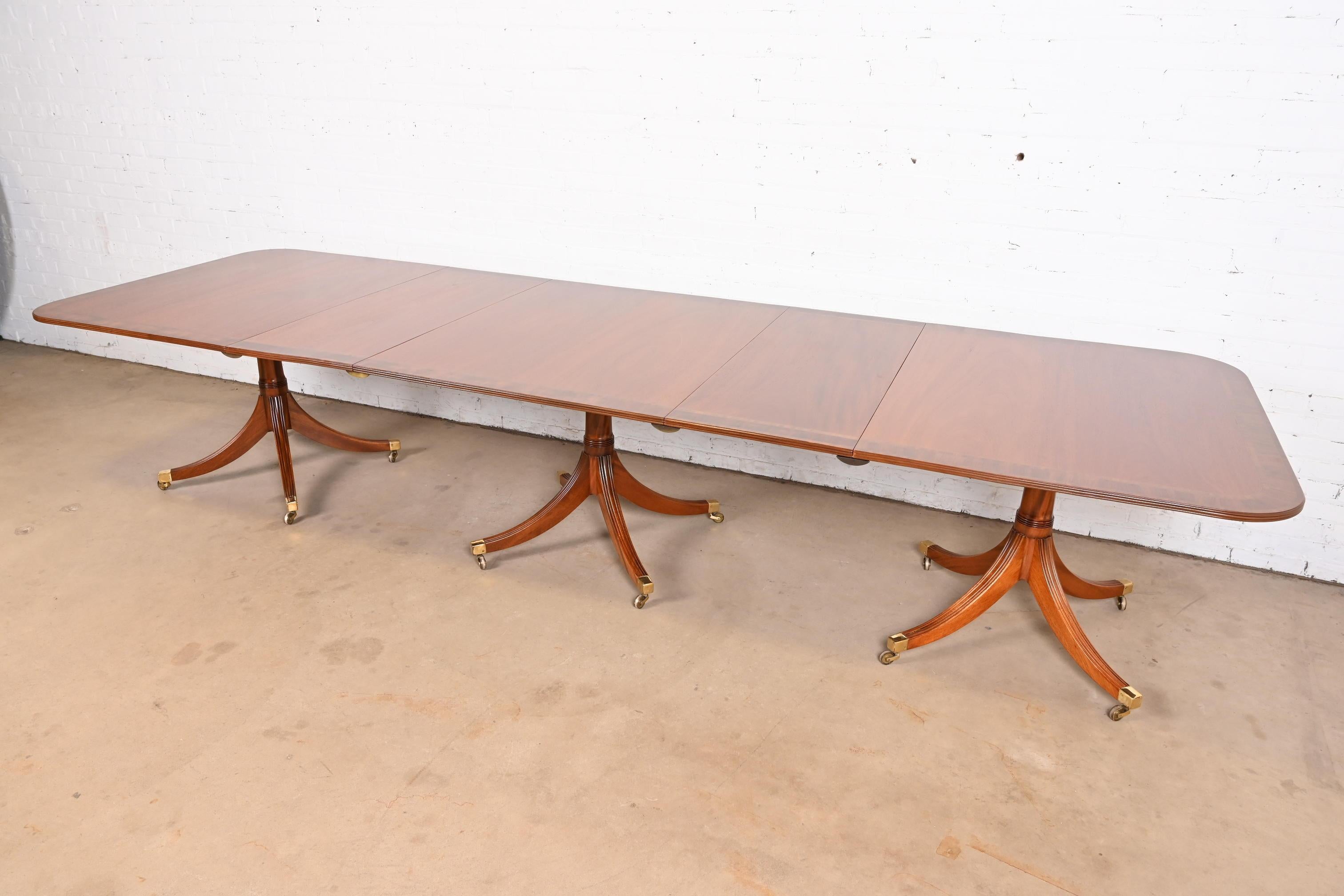 Magnifique table de salle à manger à trois pieds de style géorgien ou régence.

À la manière des meubles Baker

États-Unis, vers les années 1940

Magnifique acajou, avec bandes de bois de rose, piédestaux en acajou massif sculpté, et pieds coiffés