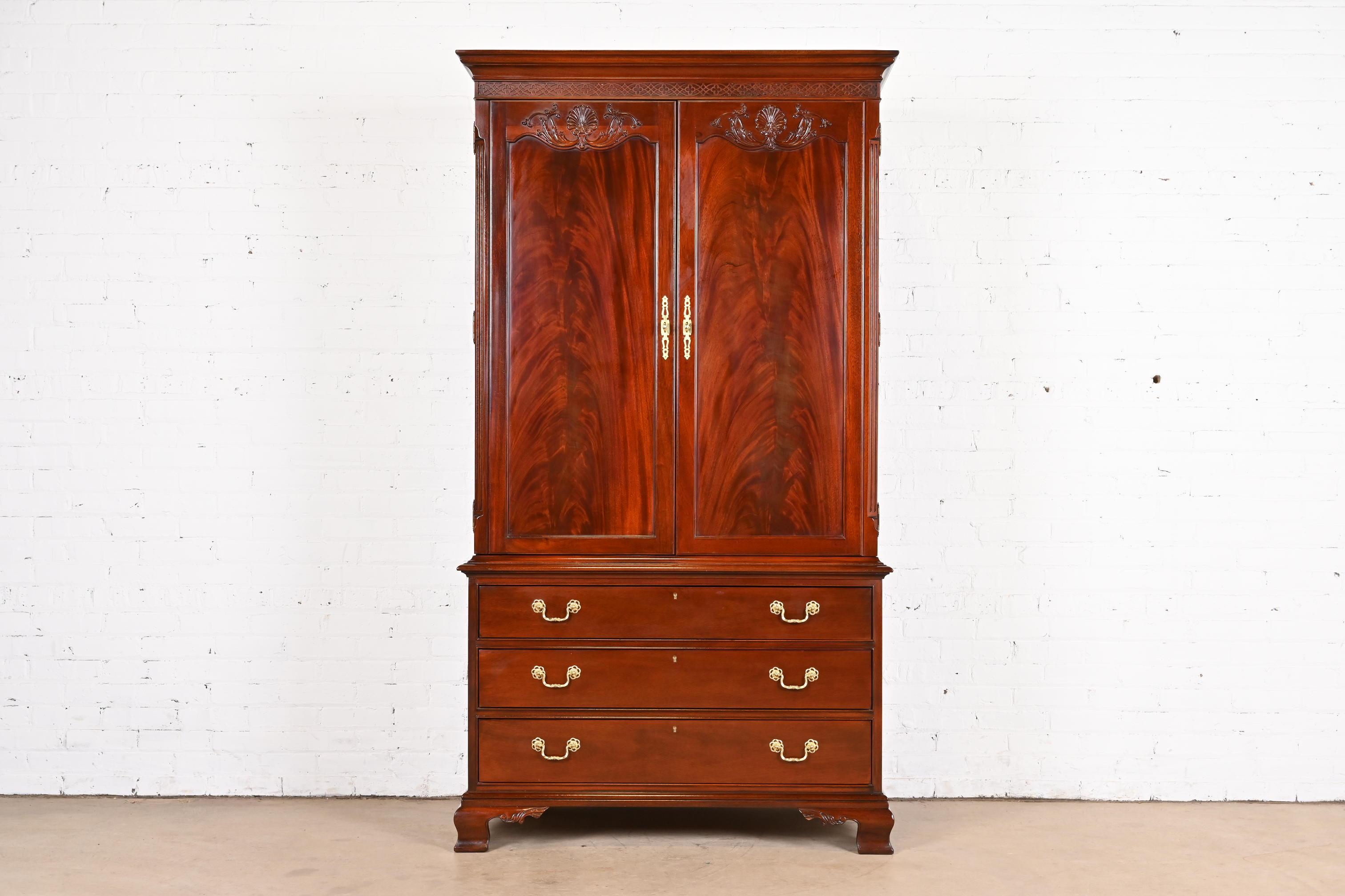 A gorgeous Georgian or Chippendale style armoire dresser or gentleman's chest

In the manner of Baker Furniture

USA, Circa 1980s

Carved flame mahogany, with original brass hardware.

Measures: 44.25