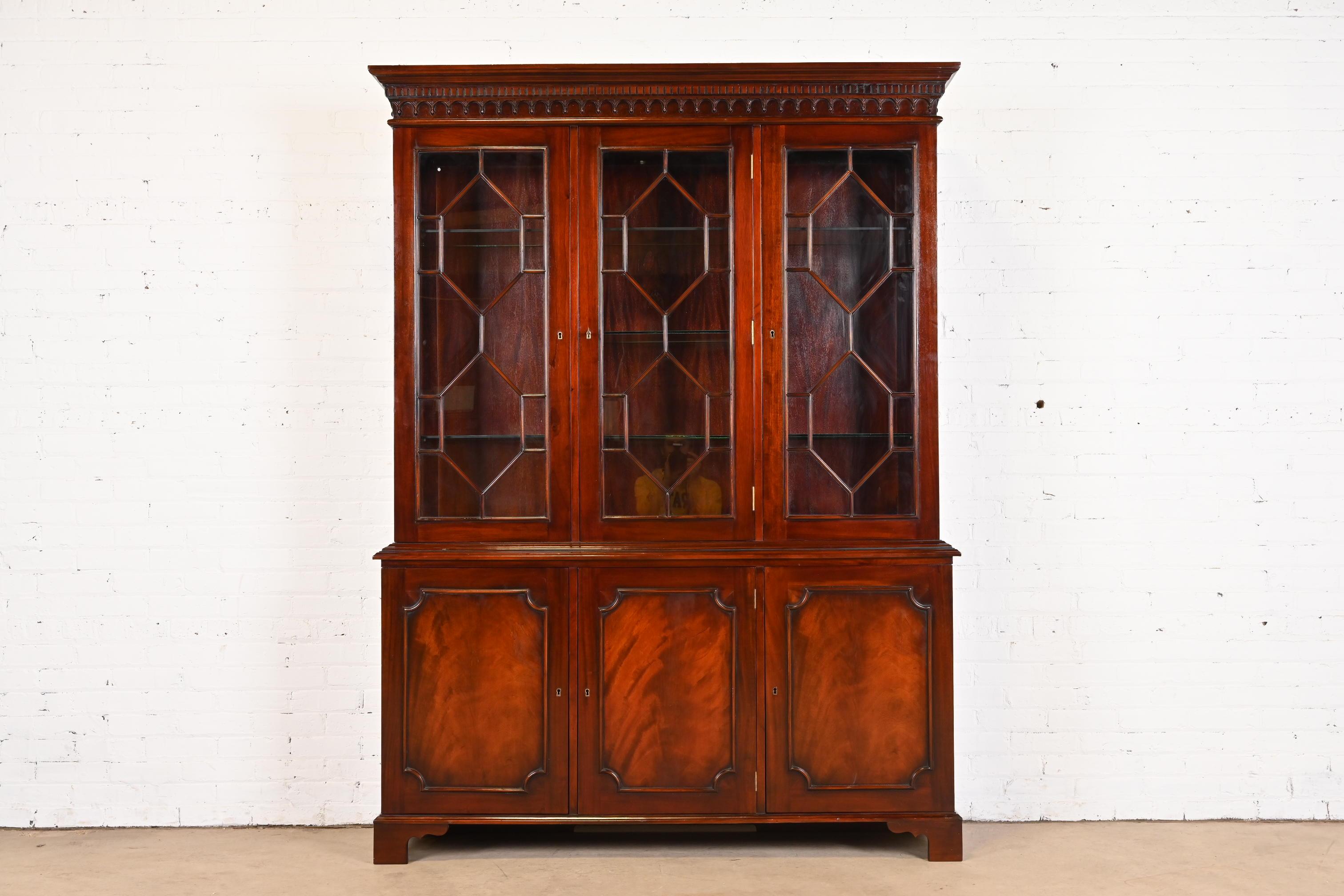 A gorgeous Georgian or Chippendale style breakfront bookcase or dining cabinet

In the manner of Baker Furniture

USA, Late 20th Century

Stunning carved flame mahogany, with mullioned glass front doors, and original brass hardware. Cabinets lock,