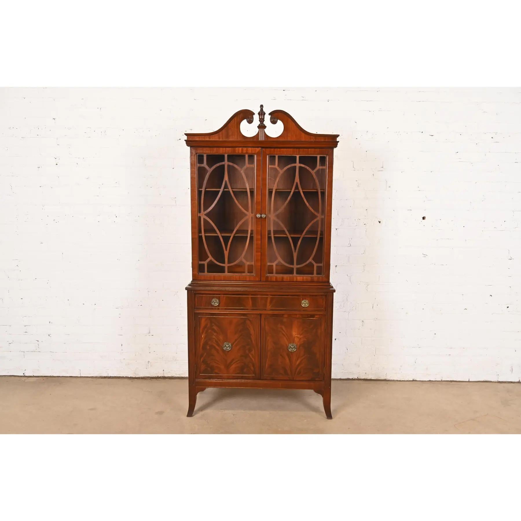 Ein schöner Bücherschrank oder Esszimmerschrank im georgianischen oder Chippendale-Stil mit gebrochener Front

Nach dem Vorbild von Baker Furniture

Von Trogdon Furniture

USA, Mitte des 20. Jahrhunderts

Geschnitztes, geflammtes Mahagoni, mit