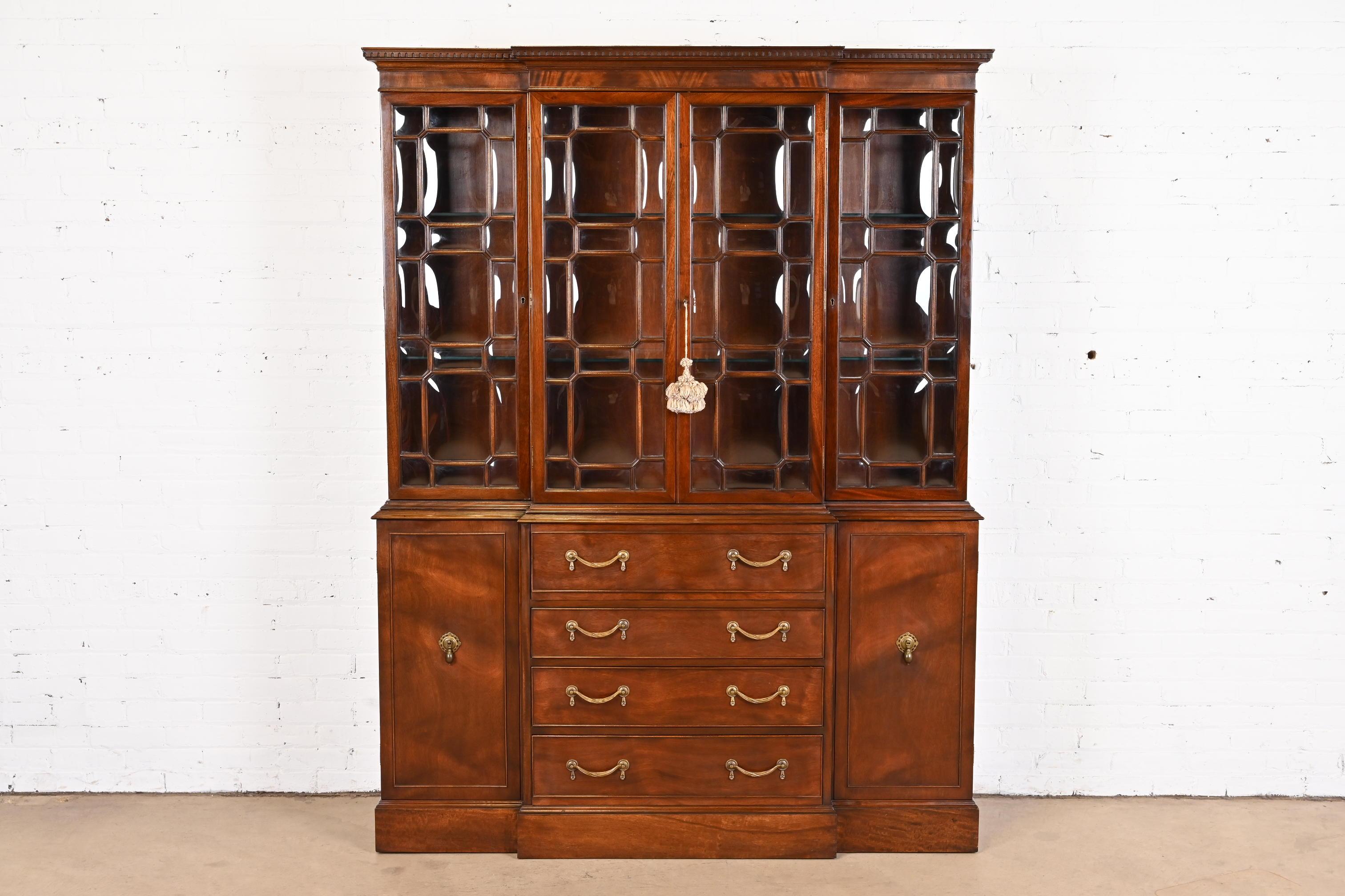 A gorgeous Georgian or Chippendale style breakfront bookcase or dining cabinet.

In the manner of Baker Furniture

USA, Late 20th century

Beautiful flame mahogany, with mullioned bubble glass front doors, embossed leather writing surface, and