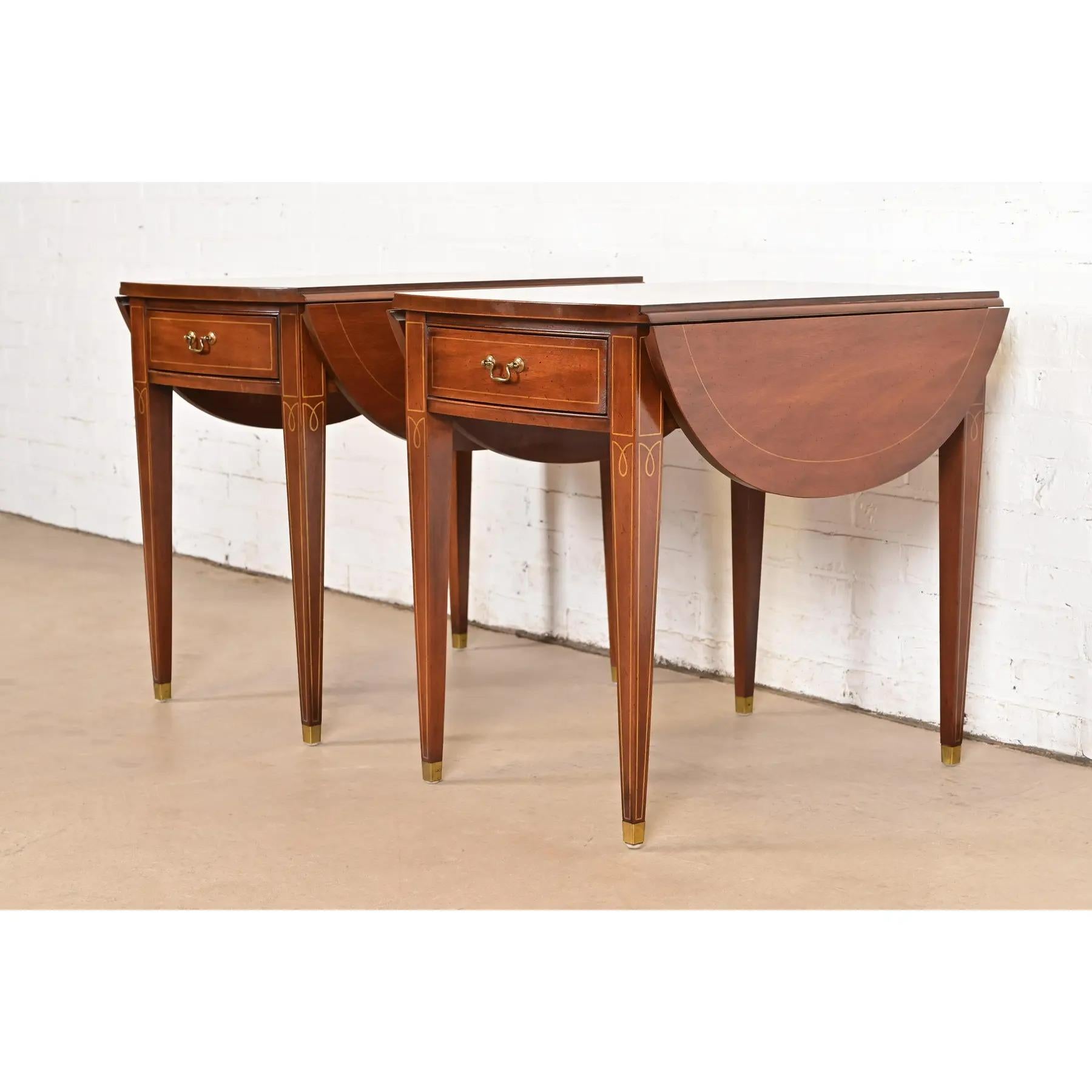 A gorgeous pair of Georgian or Regency style Pembroke nightstands, tea tables, or side tables

In the manner of Baker Furniture

USA, Circa 1980s

Mahogany, with gilt painted details, and original brass hardware.

Each measures: 19.75