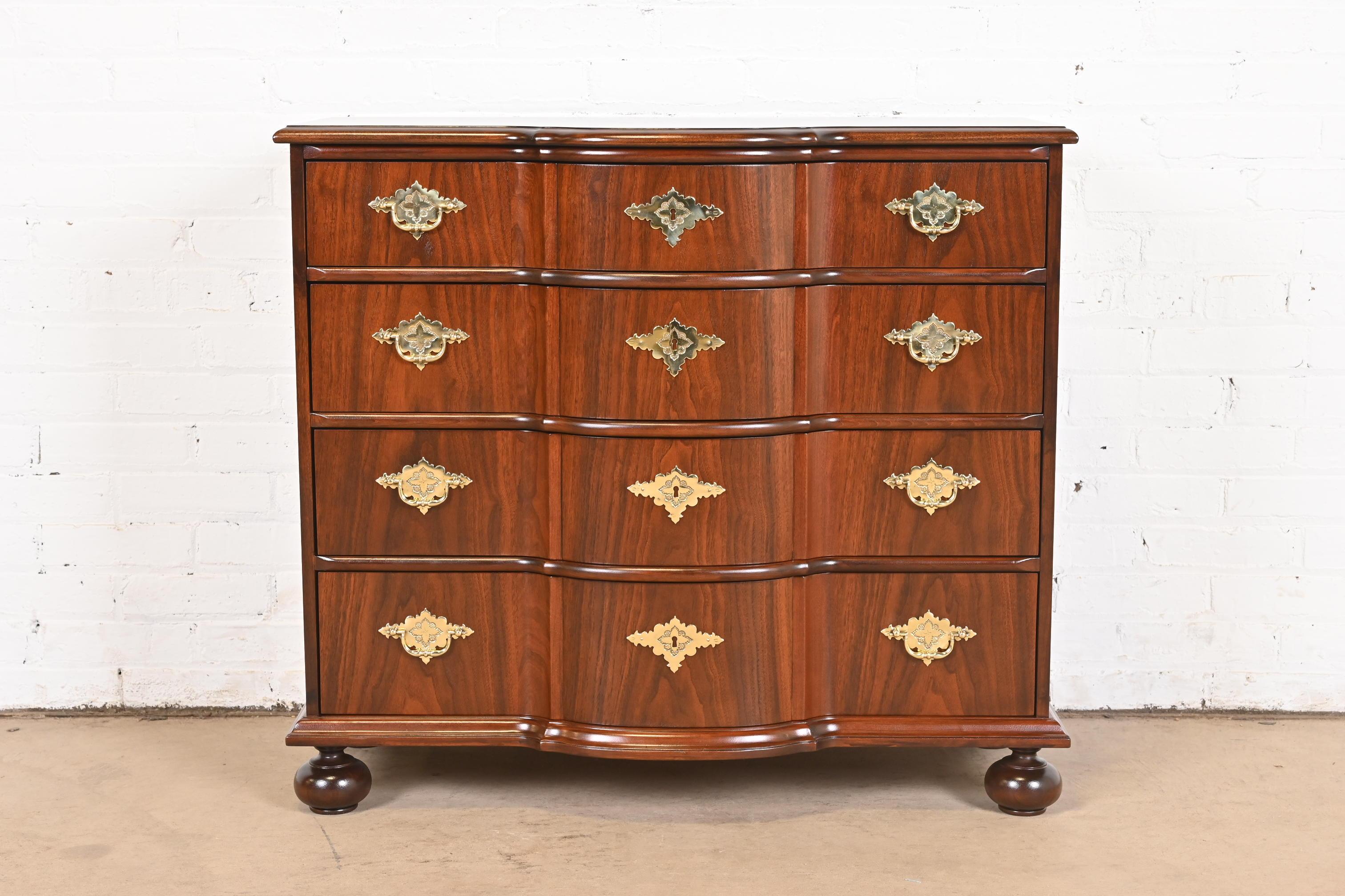 An exceptional William & Mary style commode or chest of drawers

By Baker Furniture

USA, Circa 1980s

Gorgeous book-matched walnut, with original brass hardware.

Measures: 36.25