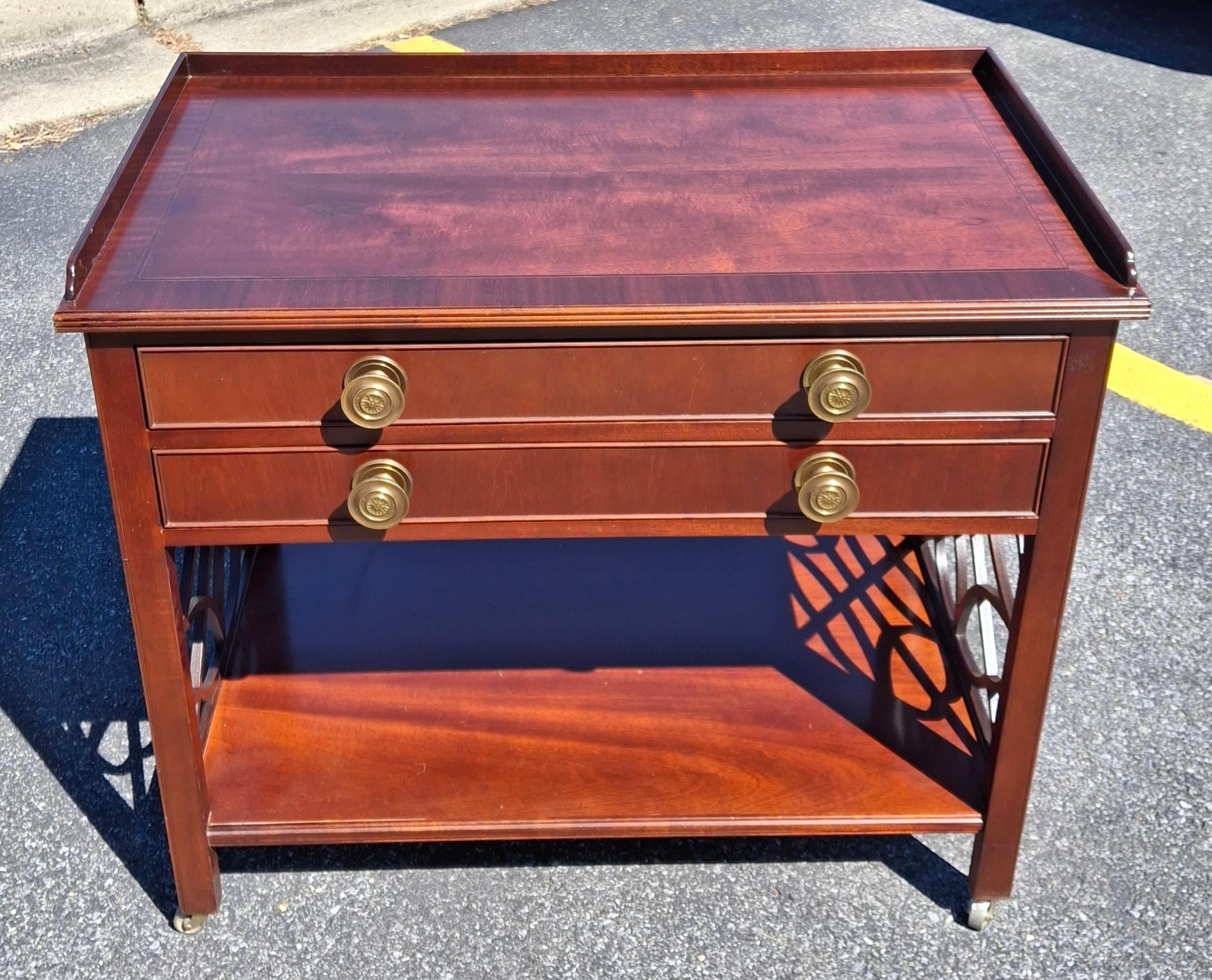 Baker Furniture Historic Charleston Collection Chippendale Mahogany style Rolling Buffet Server. Dessus à bandes croisées en excellent état. Deux grands tiroirs au-dessus d'une étagère inférieure pour plus de rangement. 
Mesure 33,75