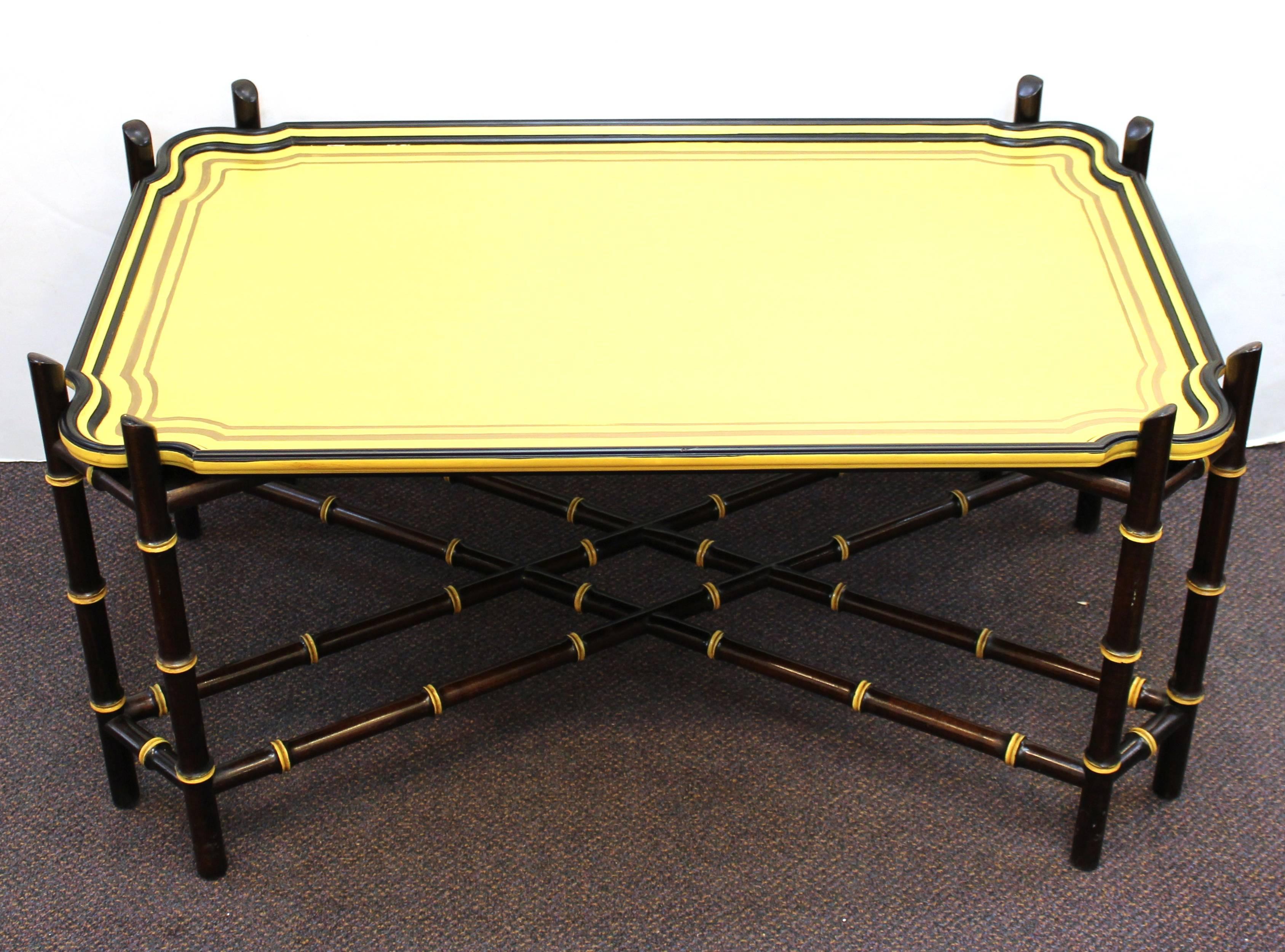 A Baker Furniture Hollywood Regency cocktail or coffee table with a bright yellow tray atop a faux bamboo base. The tray can be removed. In great vintage condition.