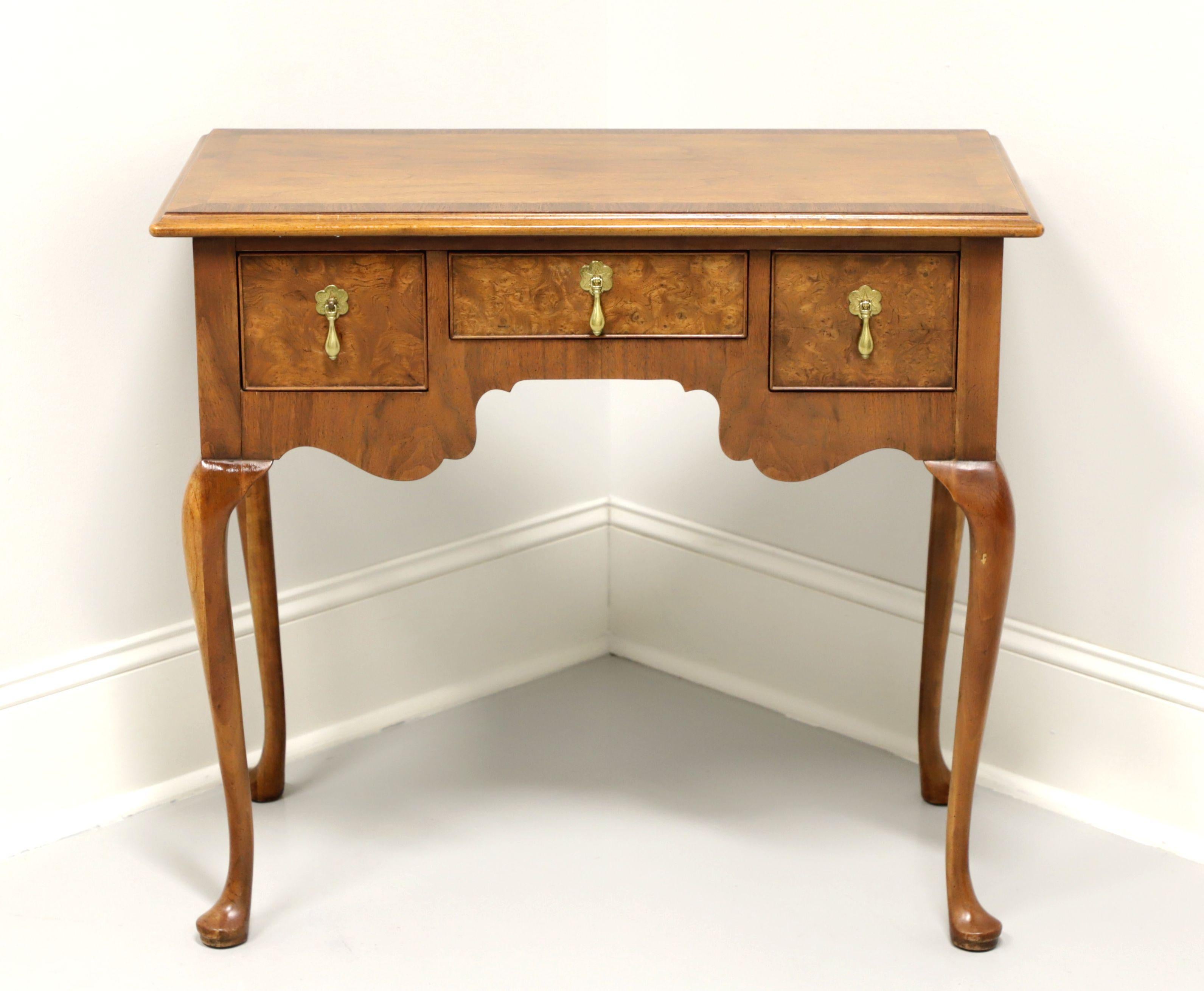 A Queen Anne style side table by top-quality furniture maker Baker Furniture, of North Carolina, USA. Walnut with inlaid banding to top and burl walnut inlays to drawer fronts. Features three dovetail drawers with brass hardware. Made in the late