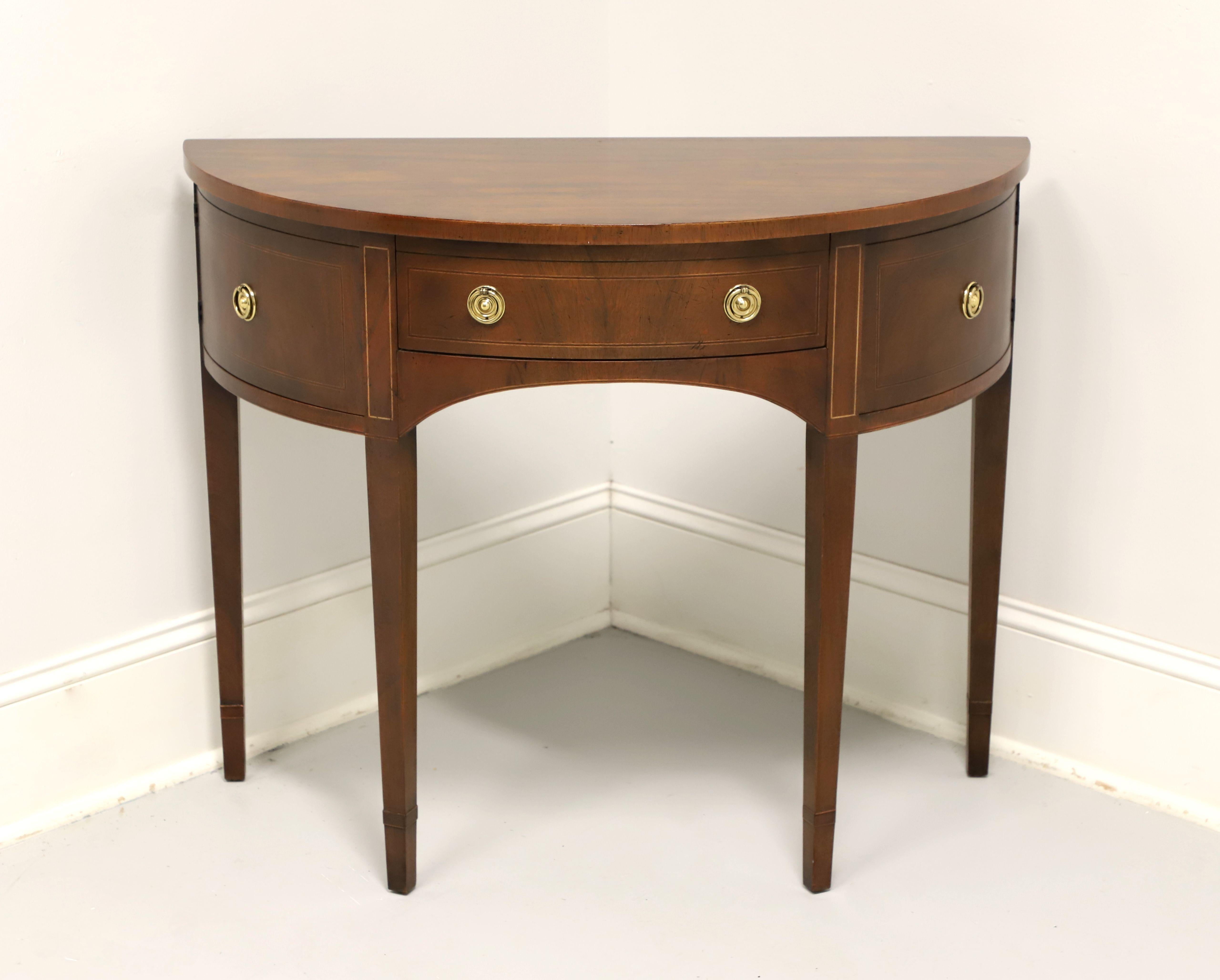 A Hepplewhite style demilune console table or server by top-quality furniture maker Baker Furniture. Mahogany with smooth edge to top, inlays to doors, drawer & top of legs, arched apron, and straight tapered legs. Features a center drawer of
