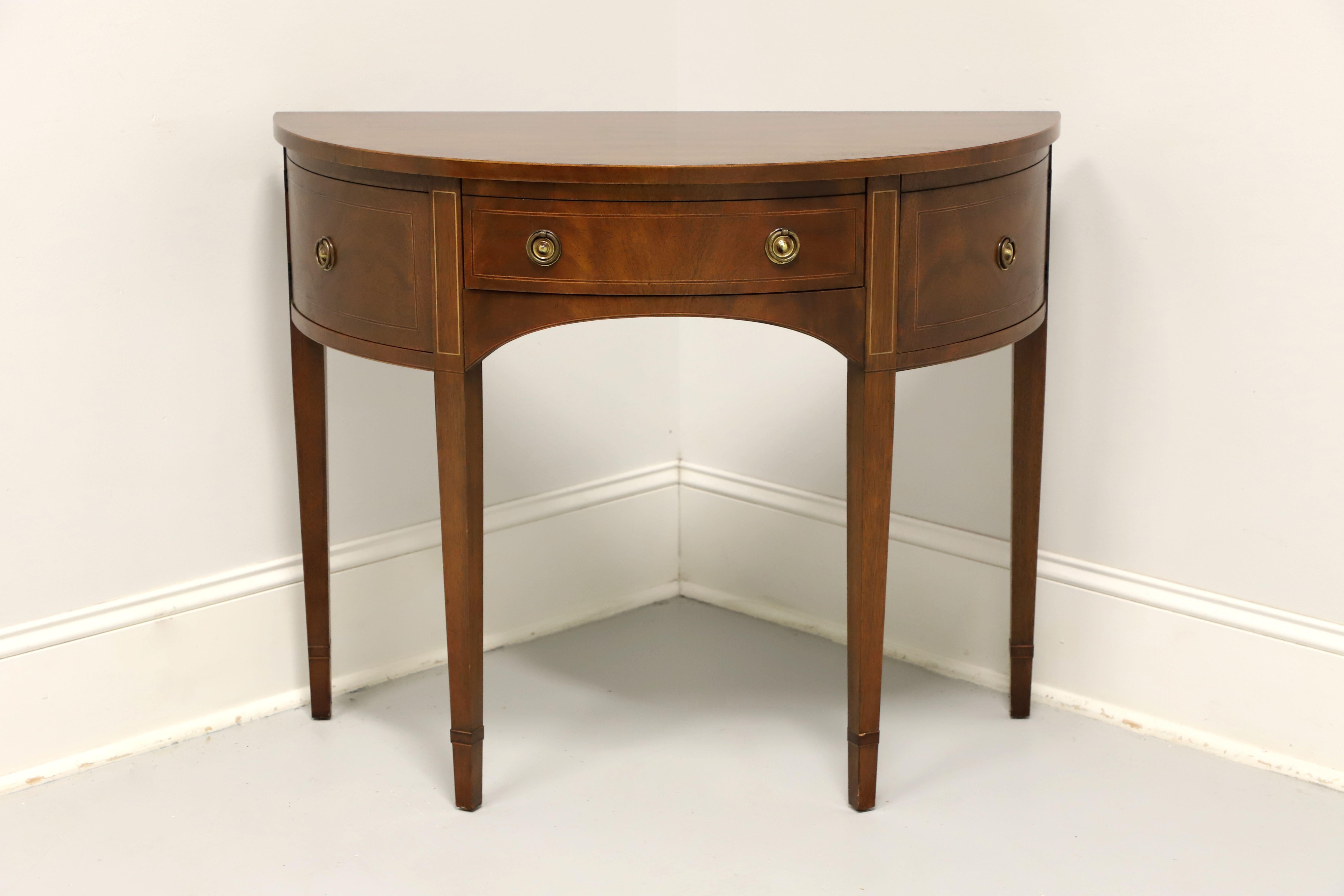 A Hepplewhite style demilune console table or server by top-quality furniture maker Baker Furniture. Mahogany with smooth edge to top, inlays to doors, drawer & top of legs, arched apron, and straight tapered legs. Features a center drawer of