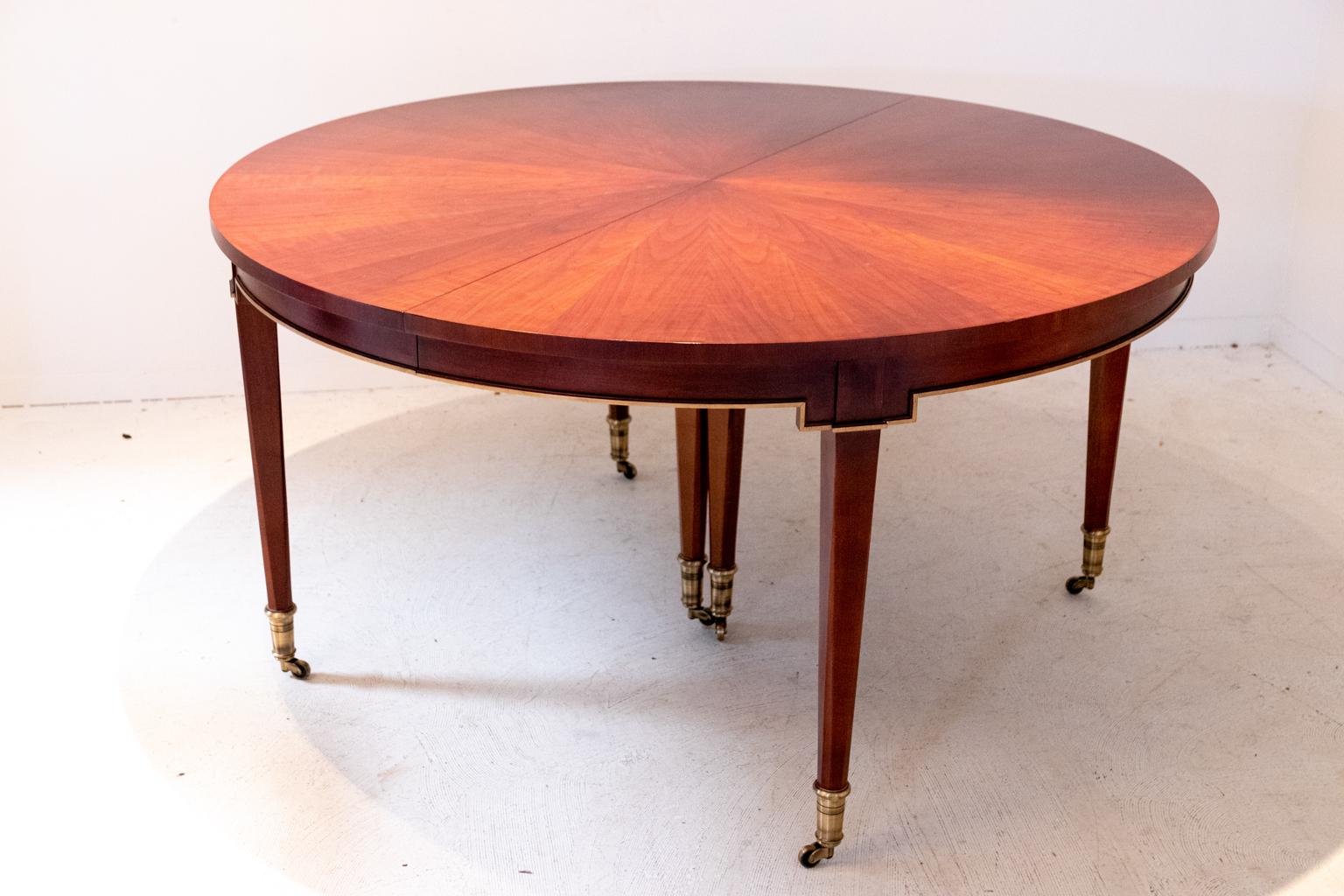 Mahogany center dining table by Baker with central fan design and brass details, circa mid-20th century. The piece comes in two parts. Made in the United States. Please note of wear consistent with age and evidence of restoration work such as
