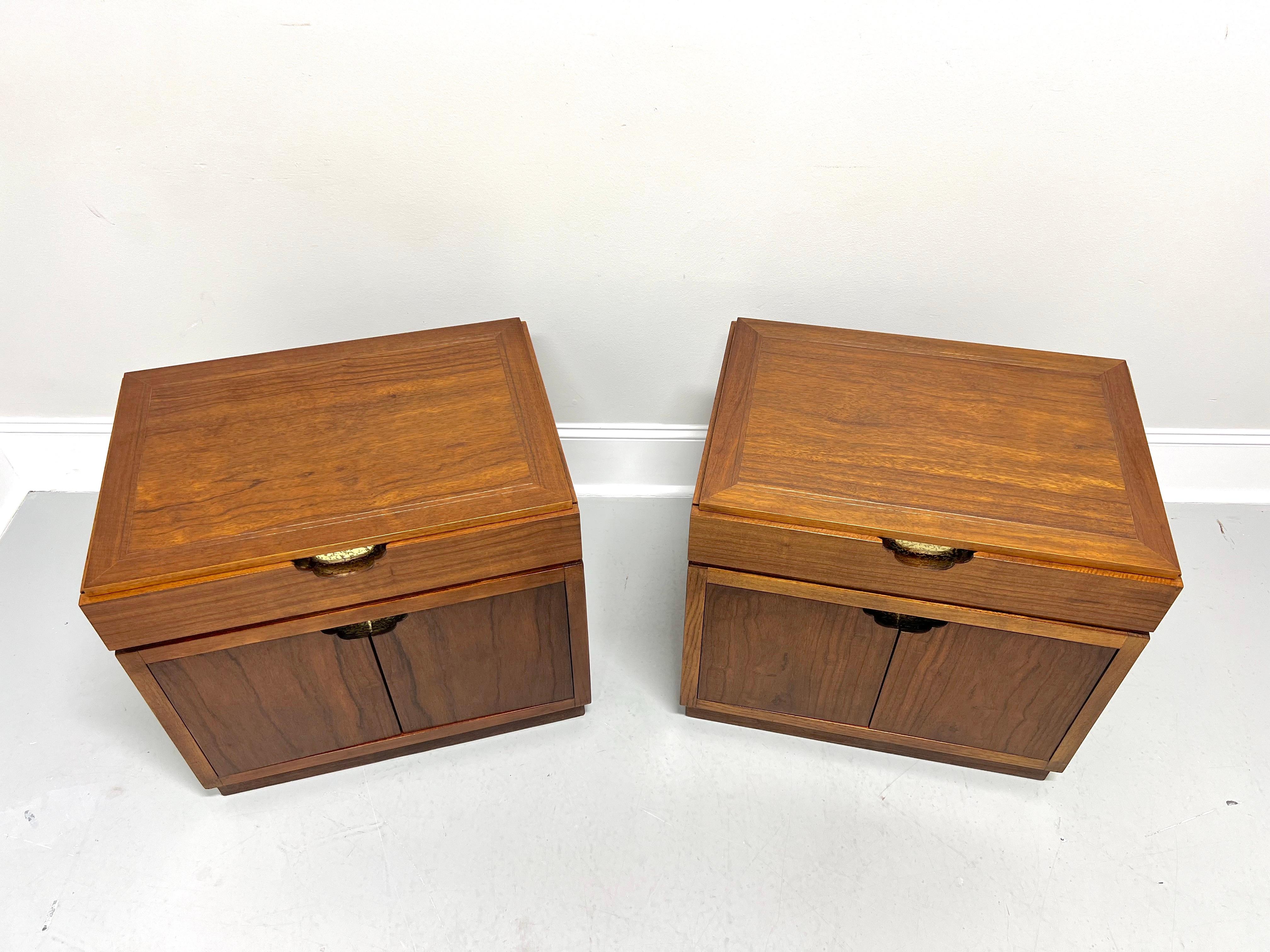 A pair of Asian inspired nightstands by Baker Furniture. Walnut frame & top, rosewood drawer, doors, side panels & rear panel, banded top, decorative stamped brass accents, wood handles, finished on all sides, and a solid base. Features one drawer