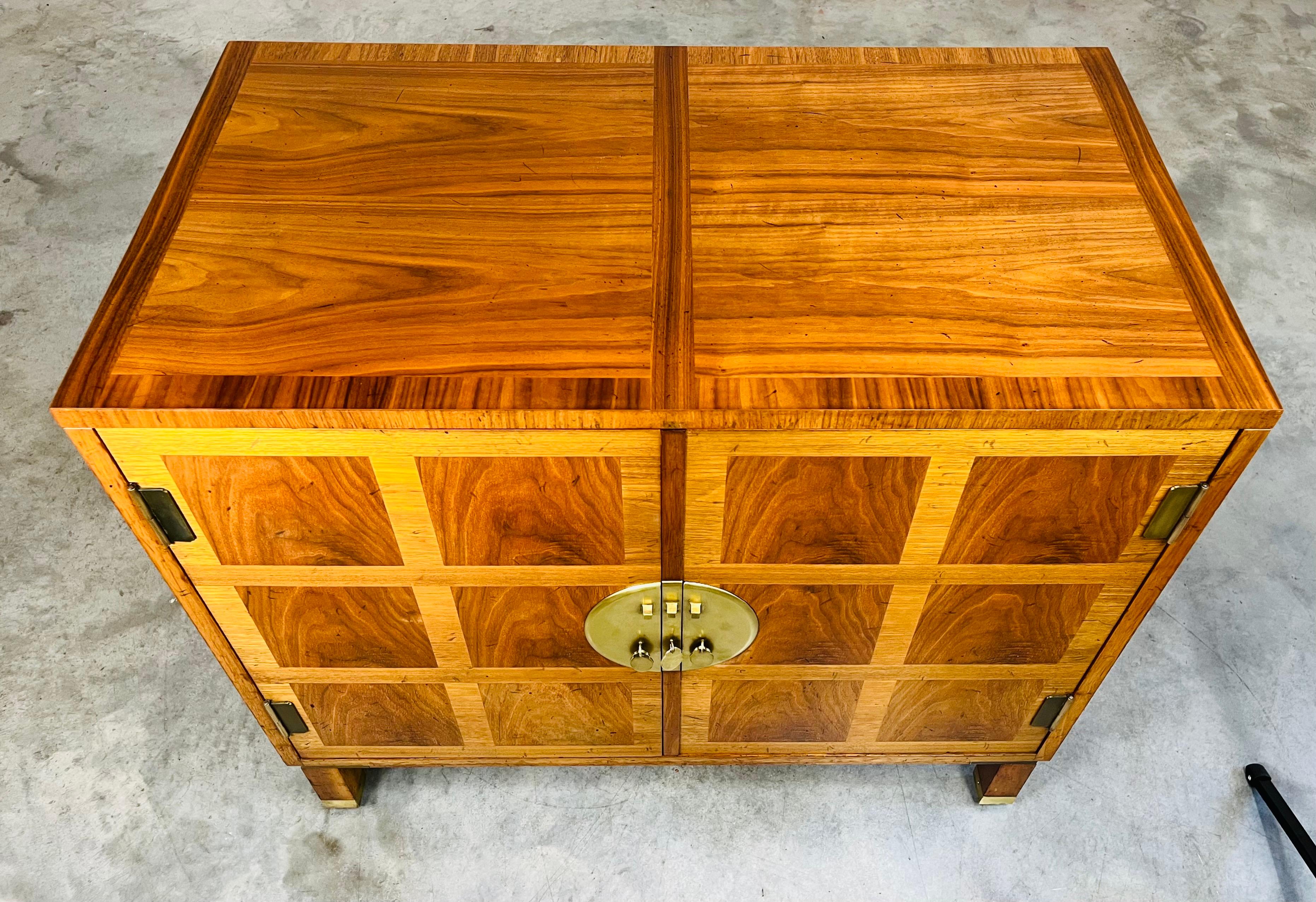 A beautiful Asian inspired banded walnut server having brass pulls with decorative back plates by Baker Milling Road model 6250. North America circa 1970. In beautiful condition with polished brass and refinished case. Boasting vibrant inlay & mixed