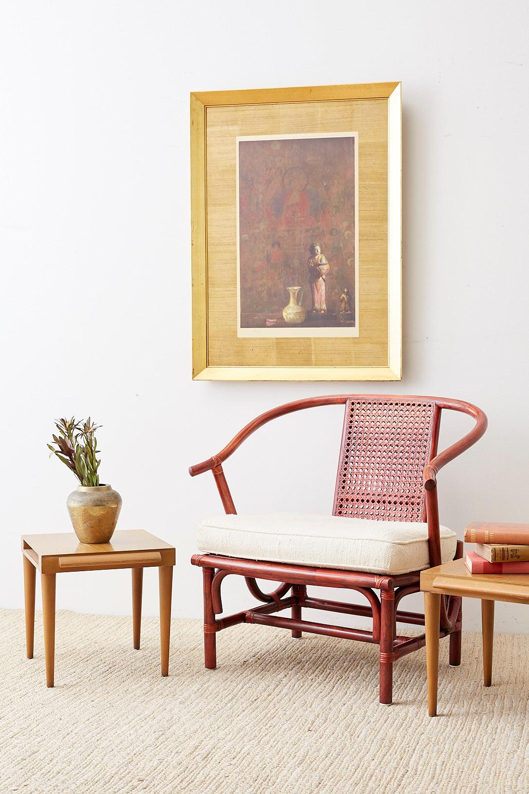 Chinese Ming style bamboo rattan horseshoe armchair by Baker Furniture features an oversized frame with a caned backsplat. Finished in a rich crimson red lacquer with a fitted seat cushion. Beautifully crafted and finished with Baker label affixed