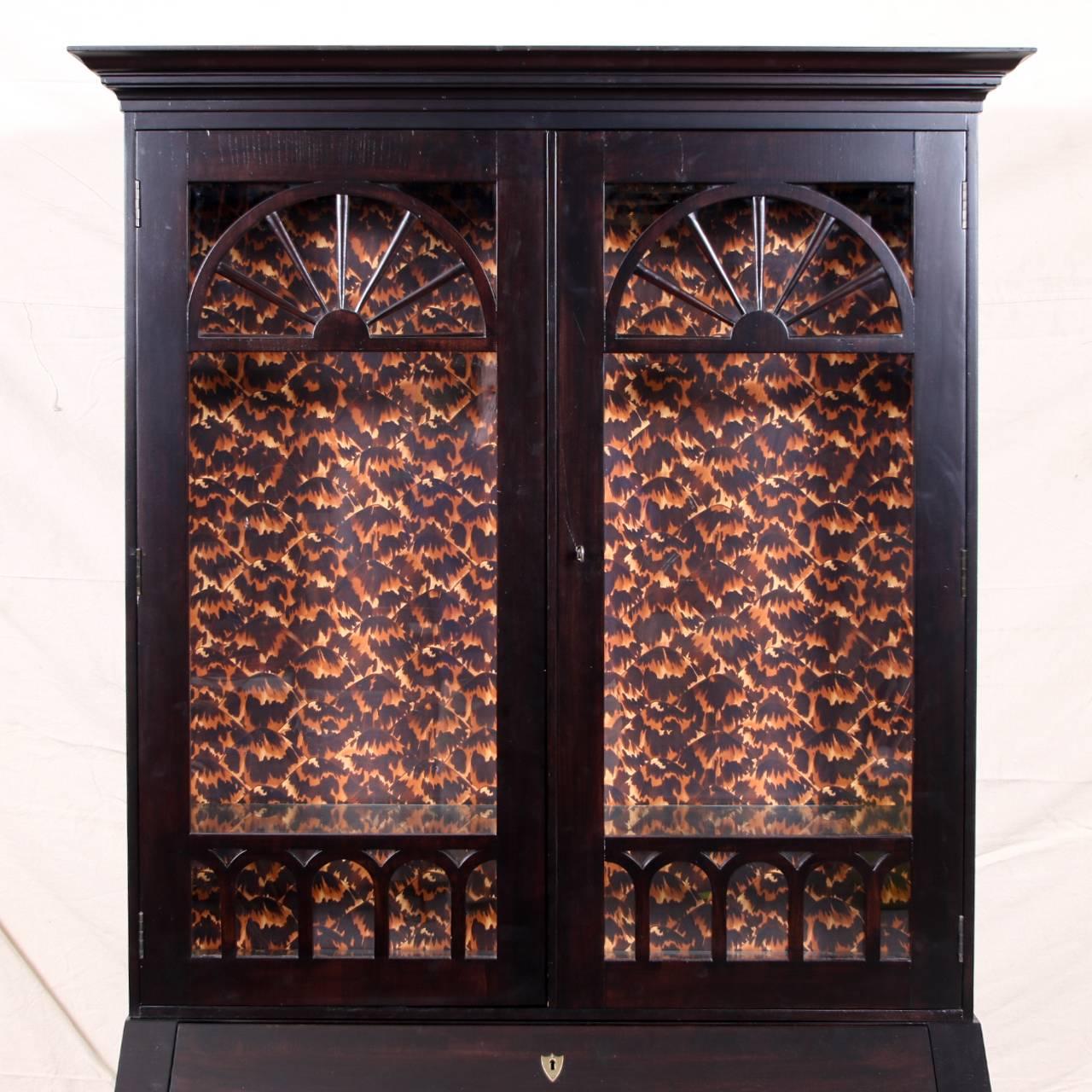Baker neoclassical ebonized secretary bookcase, double mullion doors with two glass that opens to reveal storage compartment with two shelves (the second needs to be installed) and a faux tortoise papered interior, base with secretary that opens to
