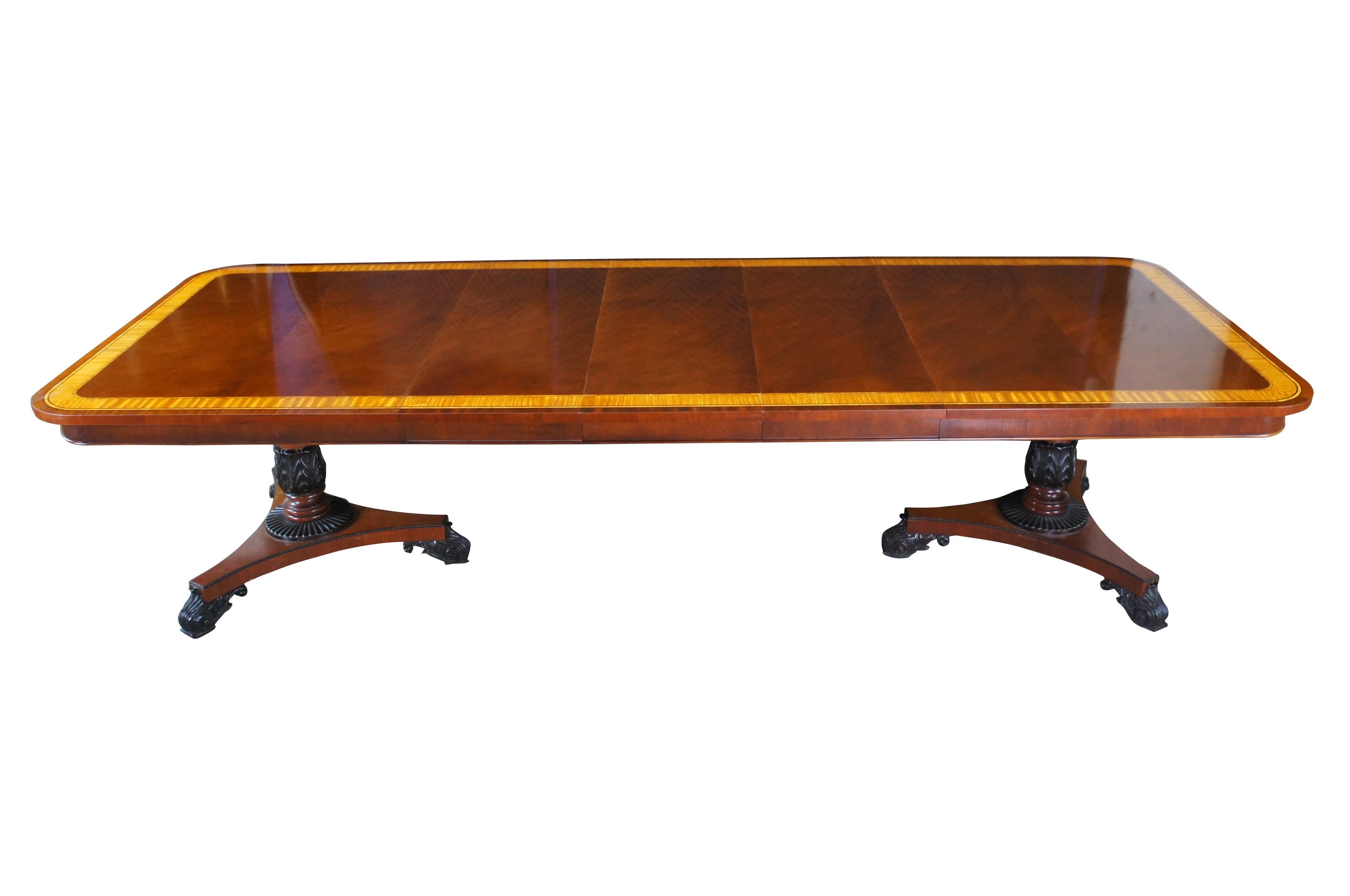 Exceptional Baker Furniture Company Dining or conference Table, circa early 2000s.  Inspired by English Regency, Neoclassical and French Empire styling.  A rectangular form with flame (crotch) mahogany top with satinwood banding and ebonized inlay.