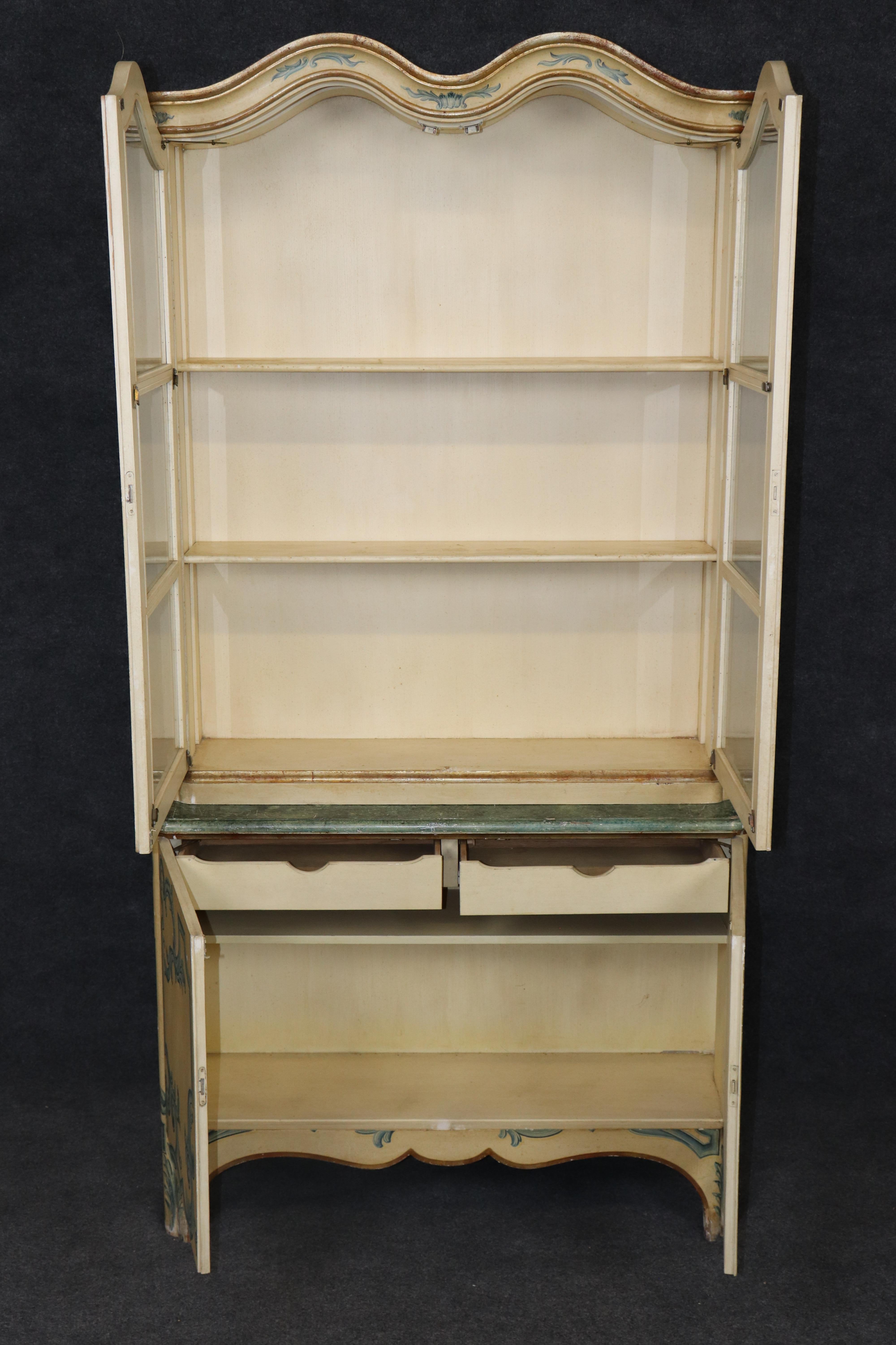 This is a truly authentic looking Baker Italian or Venetian paint decorated vitirne. The cabinet is a piece of artwork that cameos as a vitrine. The color, the vibrant painted theme and quality of the finish and condition, bring this cabinet to an