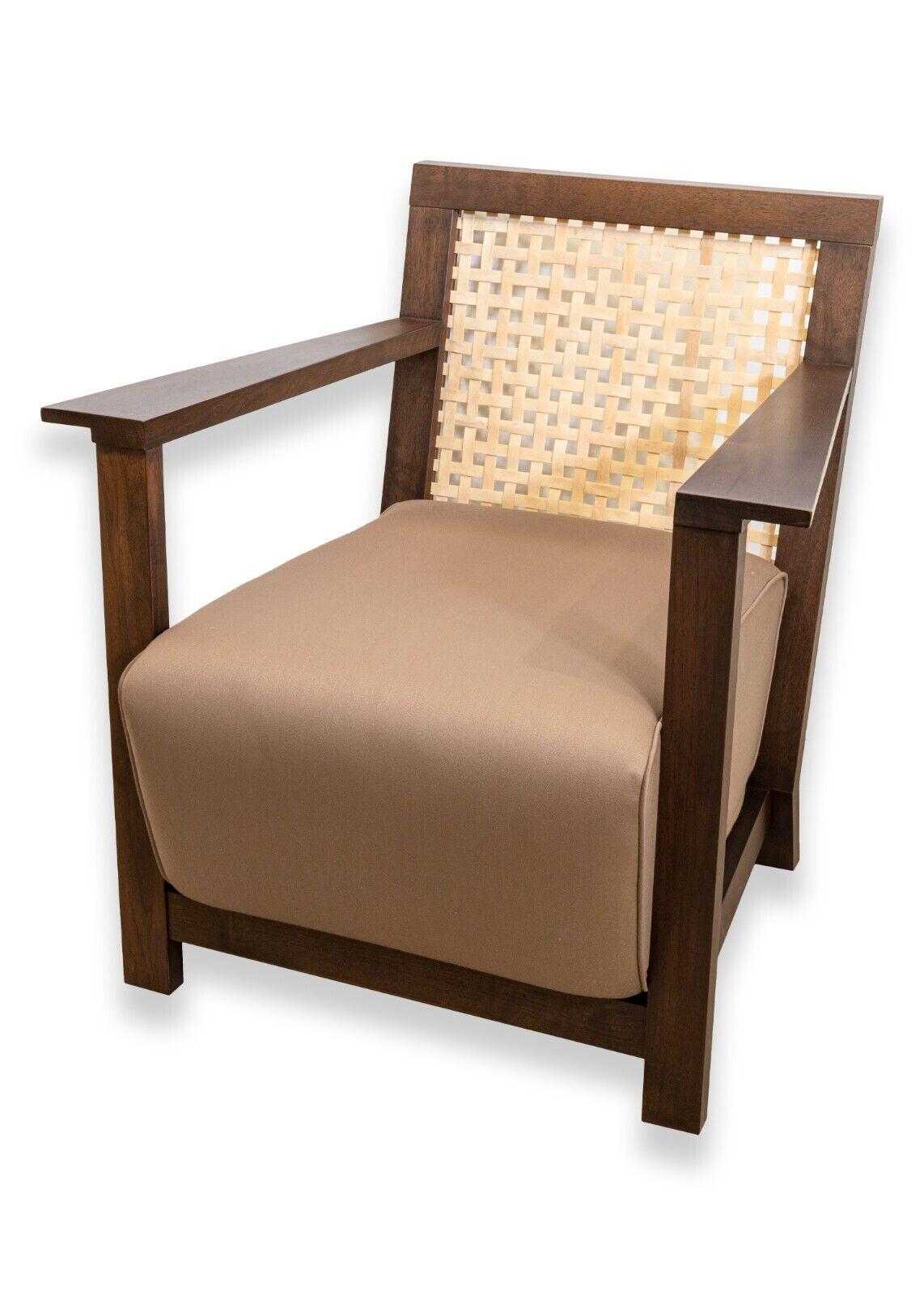 A pair of Baker contemporary cane back wood lounge chairs. This very handsome set of armchairs from Baker feature a wonderful rich, brown color, and a lovely mix of materials. They feature a dark wood frame construction with a lighter wood cane