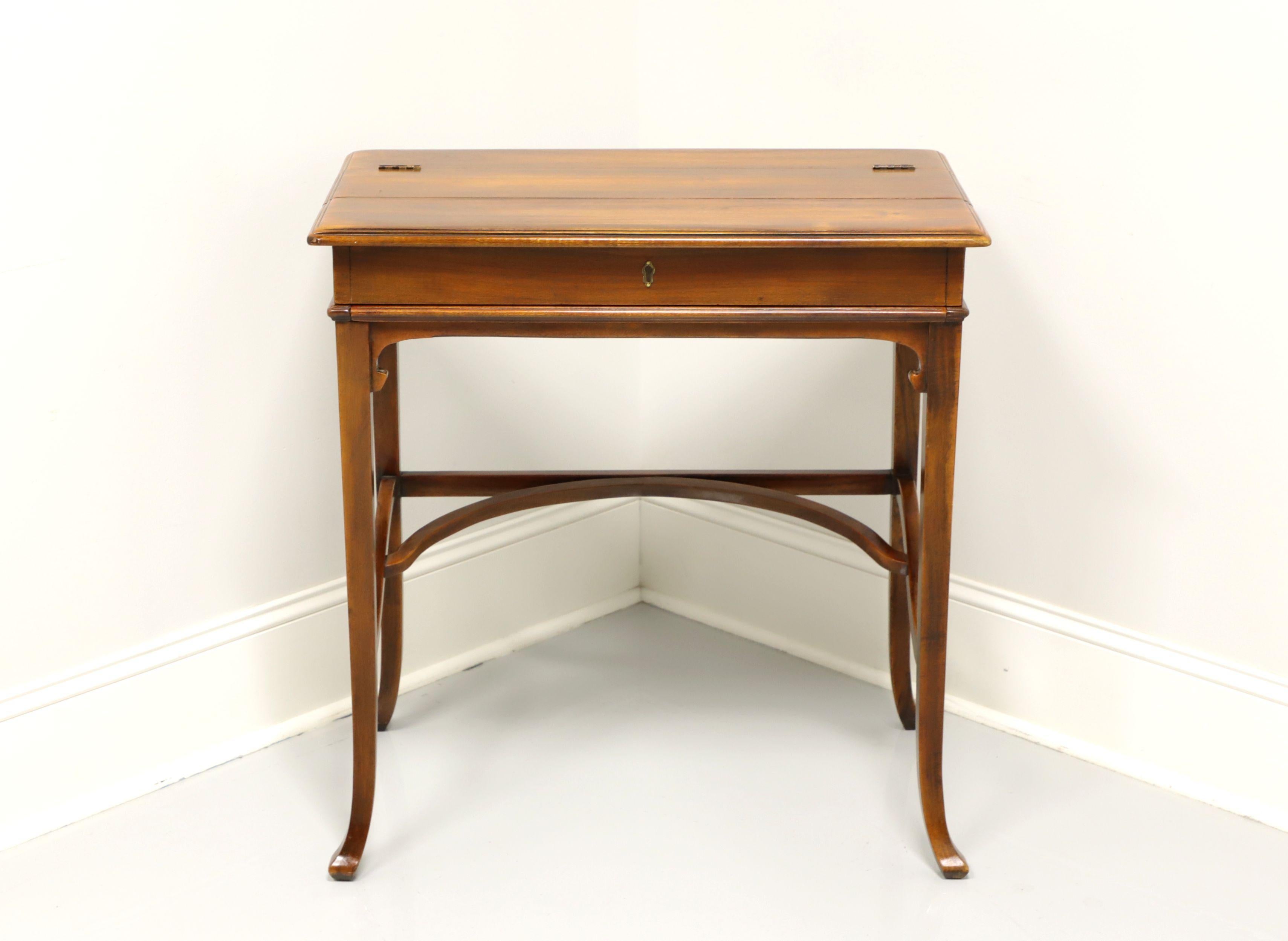 A petite campaign writing desk in the Victorian style by Baker Furniture. Elm wood with brass hinges and faux lockplate. Features a fold back top that slides out the desk surface with cubbies for storage. Made in the USA, in the late 20th