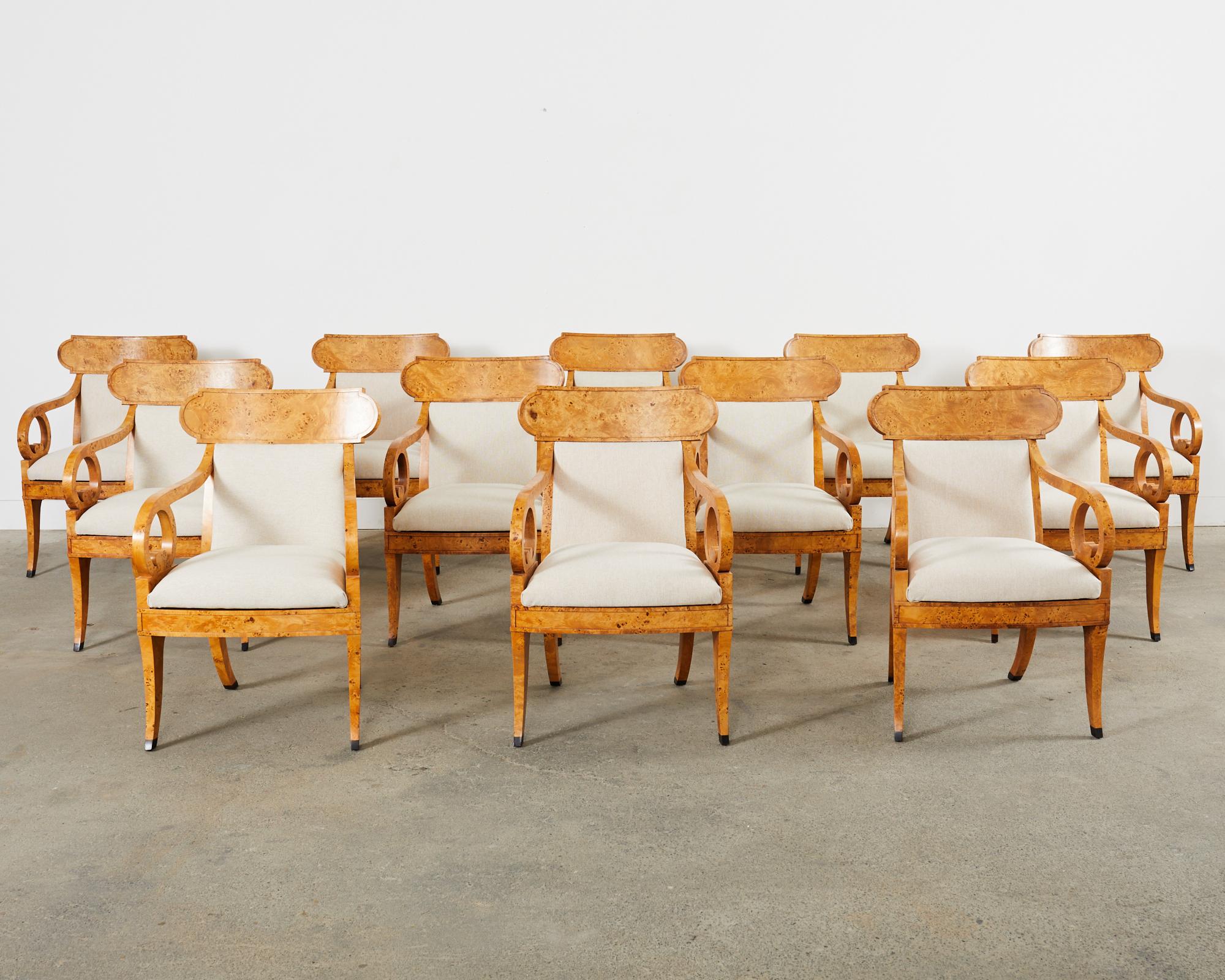Magnifique ensemble de douze fauteuils ou chaises de salle à manger en klismos de style Regency anglais, fabriqués par Baker Furniture. Les cadres sont fabriqués à la main et soigneusement recouverts de placages de bois de ronce. Le dossier incurvé