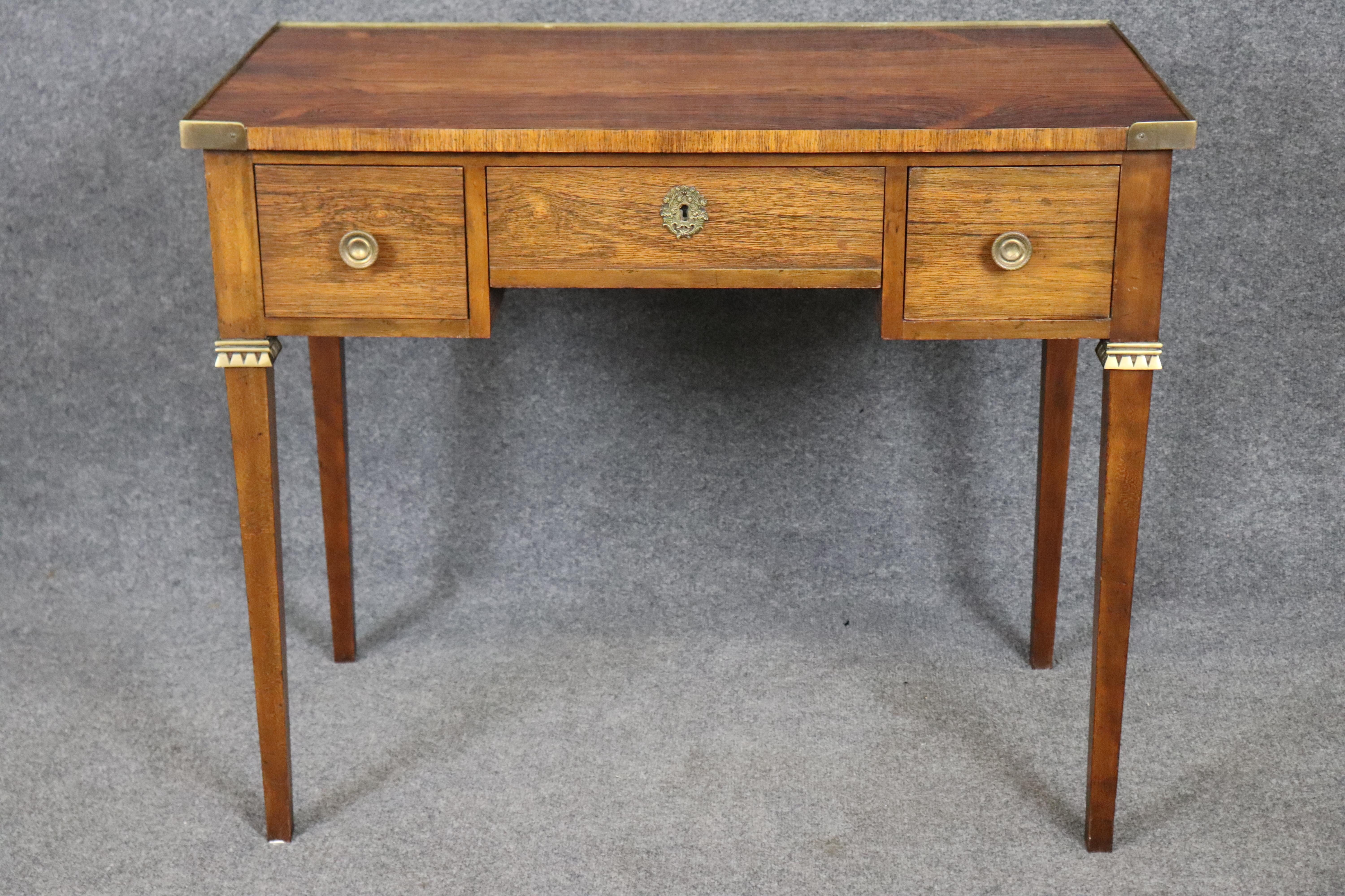 Dimensions - H: 30 1/4 in W: 36 in D: 19 1/4 in 

This Directoire style rosewood writing desk or vanity by Baker Furniture is a striking representation of neoclassical sophistication paired with American precision craftsmanship. Channeling the