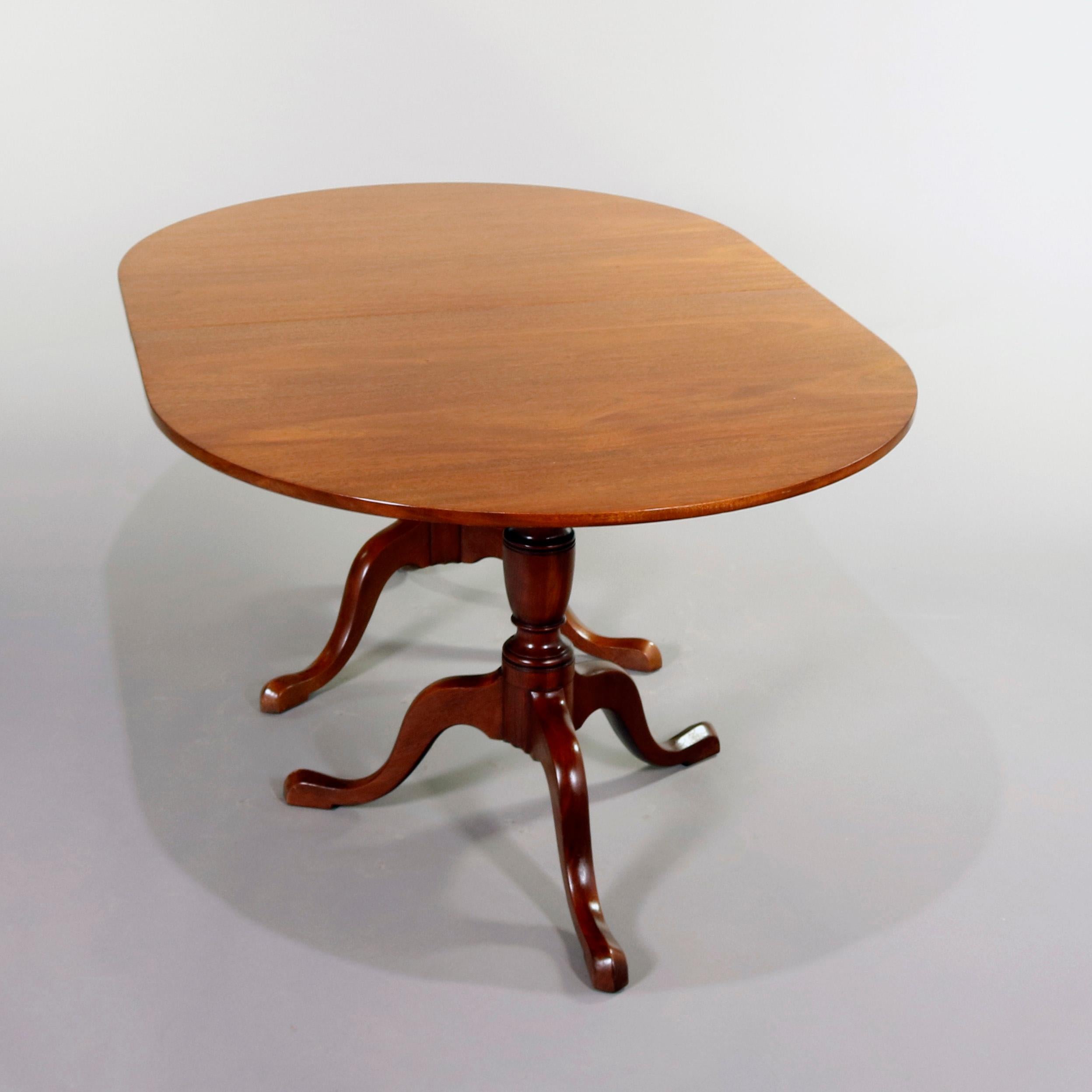 Baker School Queen Anne style dining table features mahogany construction with oval dining surface raised on double pedestal tripod bases having pad feet, without leaves, 20th century

Measures - 29.75