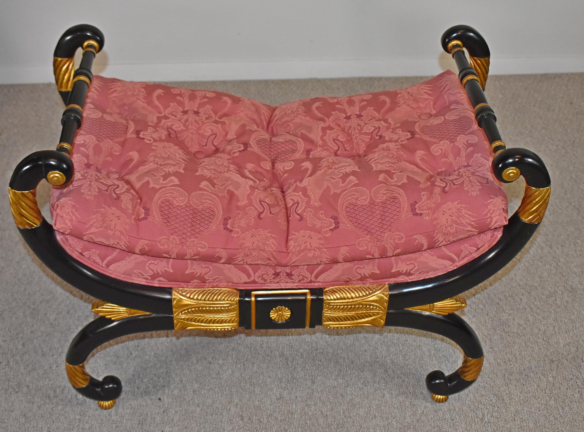 Baker Stately Homes Collection Neoclassical ebonized and gold bench. Circa 1940-1949. Baker Furniture Regency bench from the Stately Homes Collection. Features a lovely shaped X-base frame. Finely carved details are finished in black ebony and