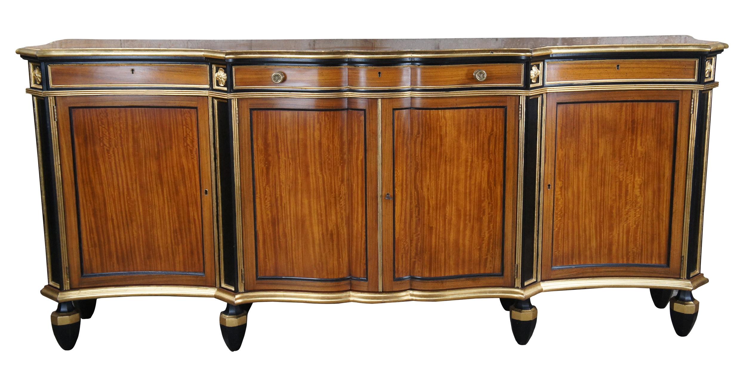 Exquisite dining room buffet, sideboard, server or hall console from The Stately Homes Collection #5230 by Baker Furniture. A serpentine form made from Satinwood with ebonized trim, carved rosettes at canted angles and giltwood borders. The frieze