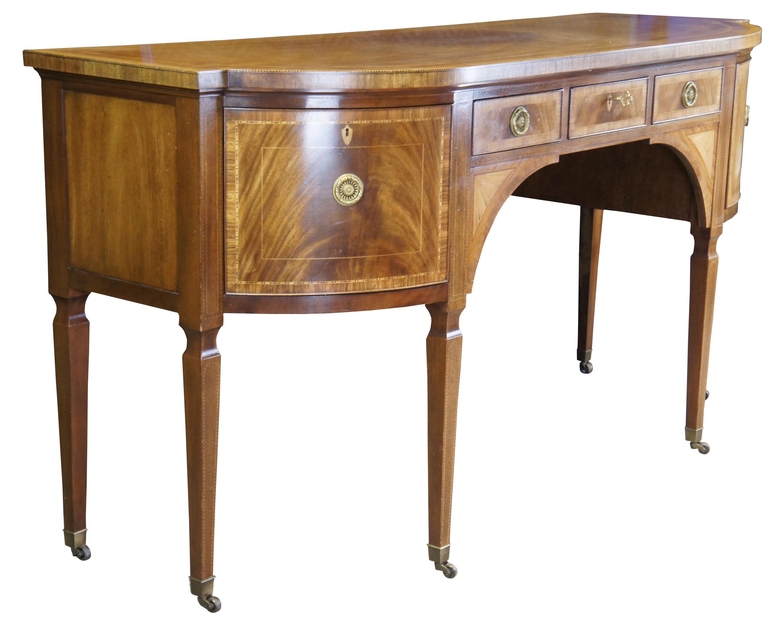 Un raro e imponente buffet o credenza in stile Hepplewhite della notevole collezione Stately Homes di Baker Furniture, risalente agli anni '80 circa. Realizzato in mogano con frontali dei cassetti in impiallacciatura crotch, bordato con intarsi in