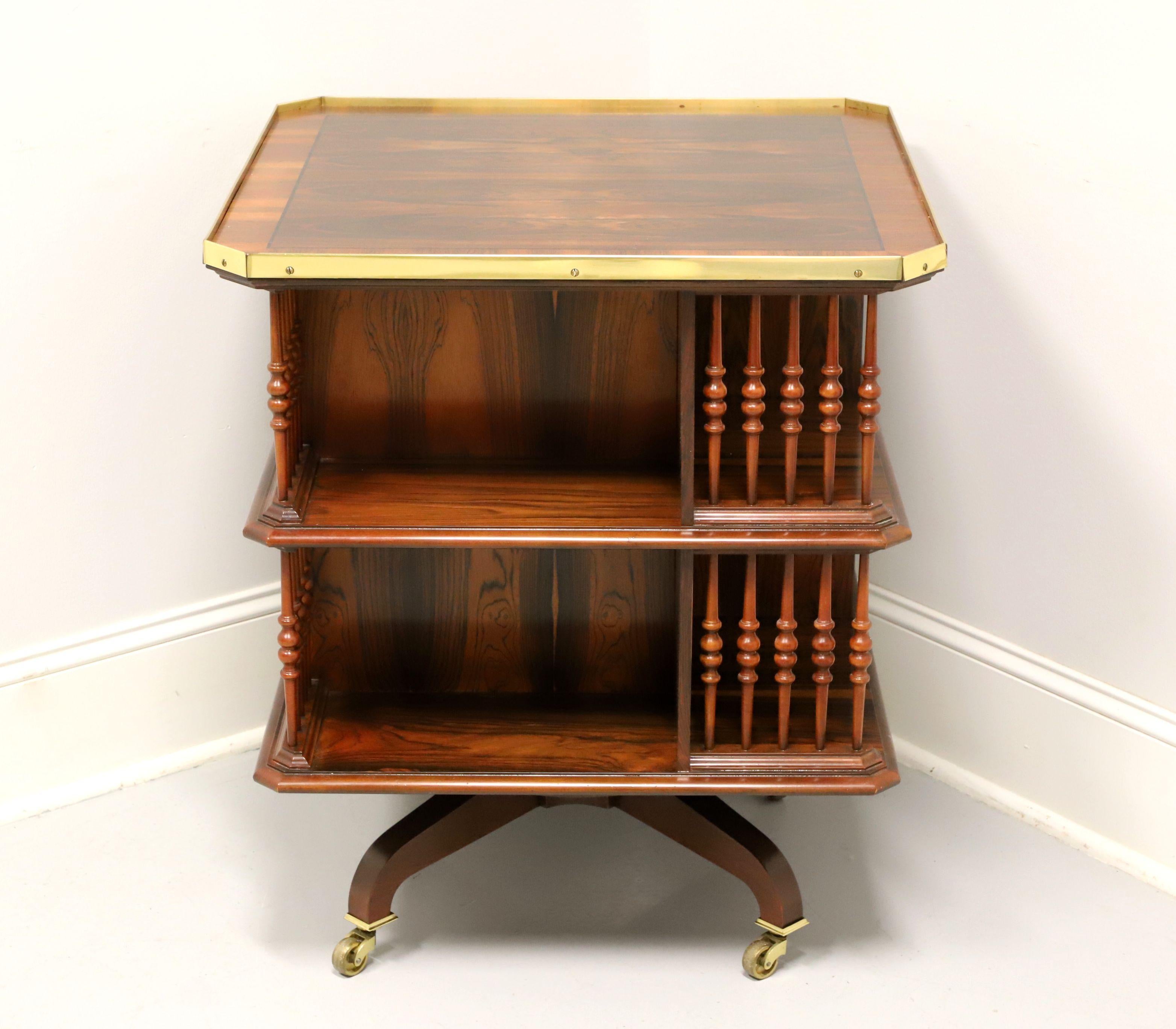 A rare, Regency style square bookcase side table by Baker Furniture, from their Stately Homes Collection. Rosewood with banded top, brass gallery, clipped corners, turned posts, revolving mechanism, and four leg base with brass casters. Features two