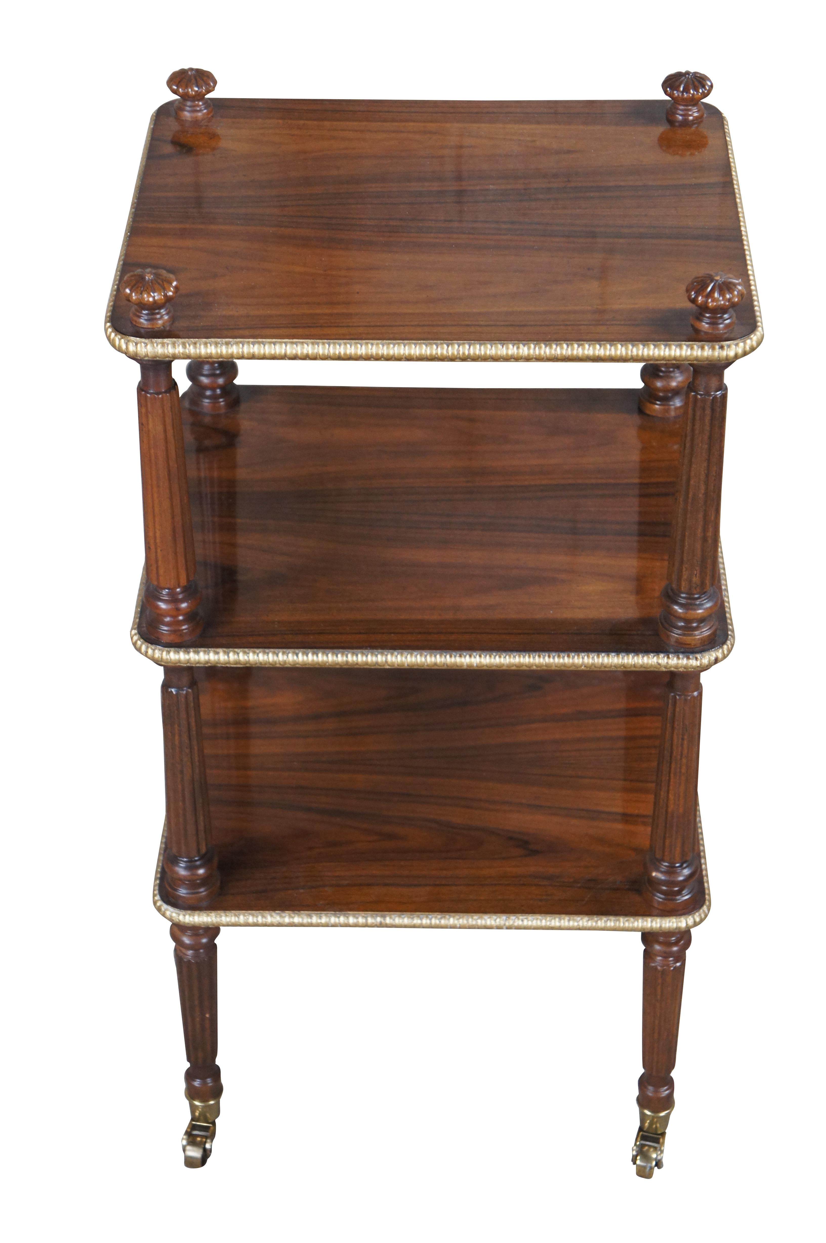 Vintage Baker Stately Homes Collection bar cart, side table or stand.  Made of rosewood featuring tiered design with gilded gadrooned edges, turned and fluted columns, ornate finials and brass castors.

The Stately Homes Collection by Baker