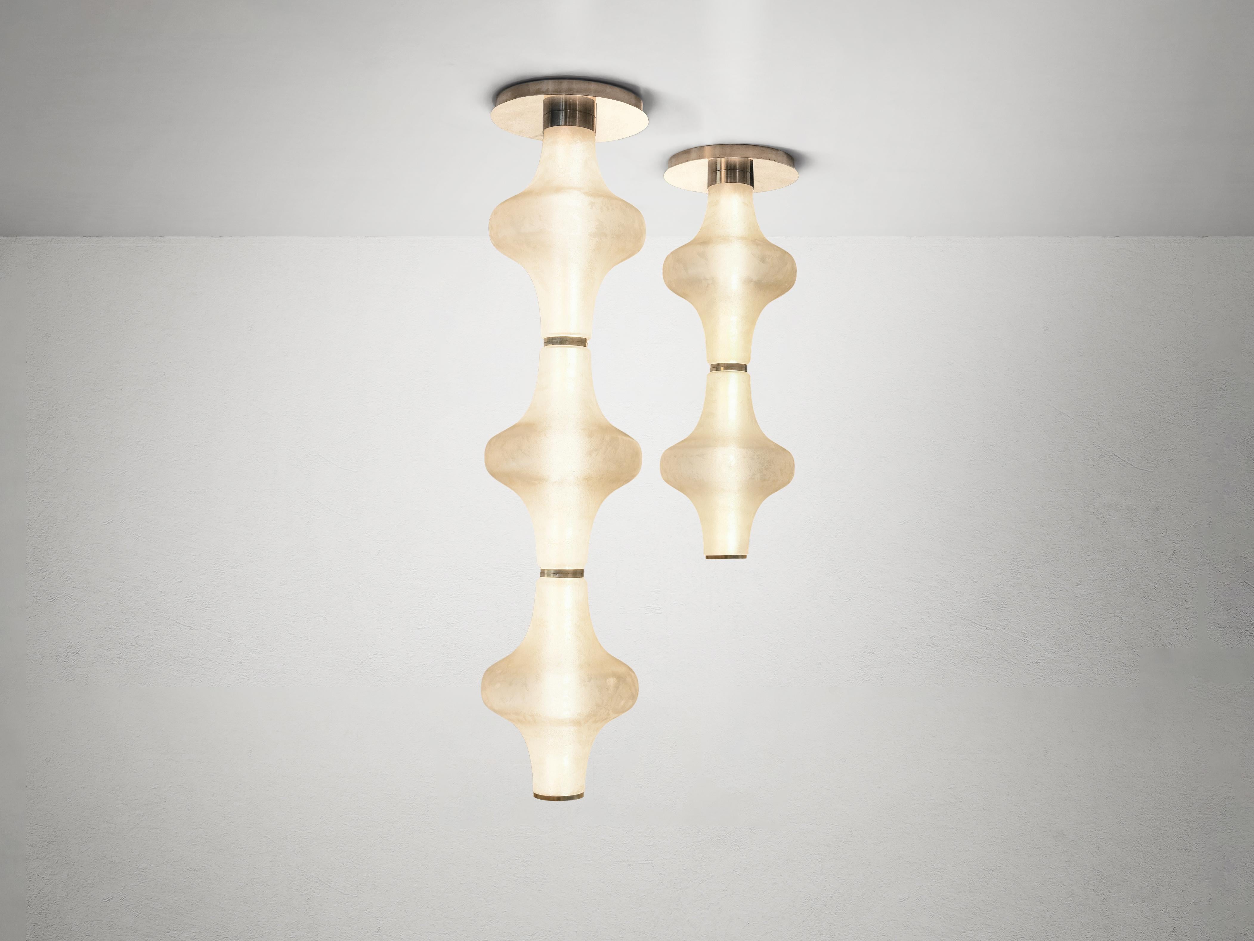 The Baker Street Muse chandelier, an embodiment of refined elegance, features a choice of two or three Murano glass shades. Each shade undergoes a meticulous acid-etching process, resulting in a soft, satin-like finish that diffuses light