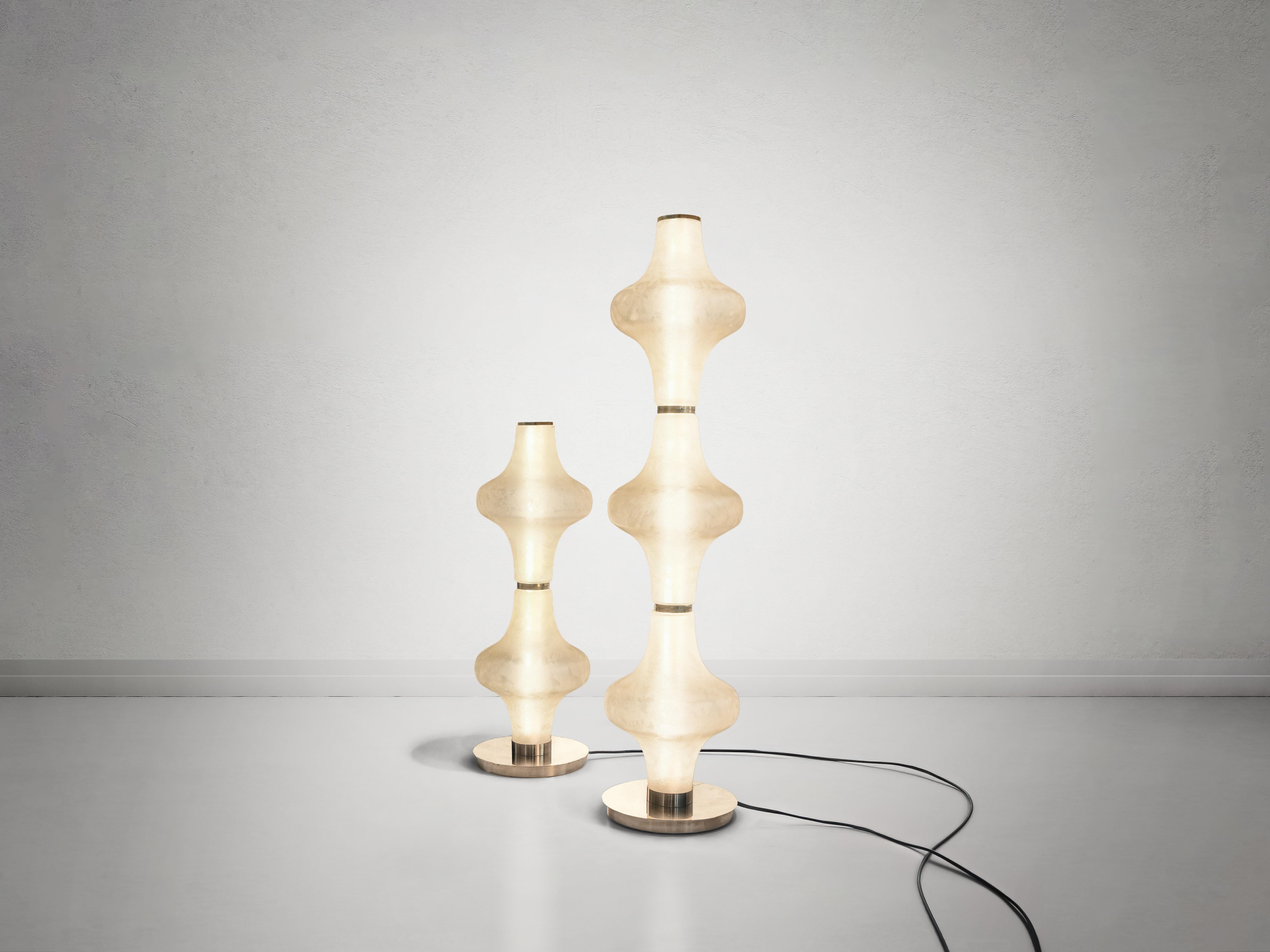 The Baker Street Muse floor lamp blends modern elegance with timeless craftsmanship. Featuring a sleek brass stand, this lamp offers a comes with two or three Murano glass shades, each meticulously acid-etched to achieve a refined satin finish. The