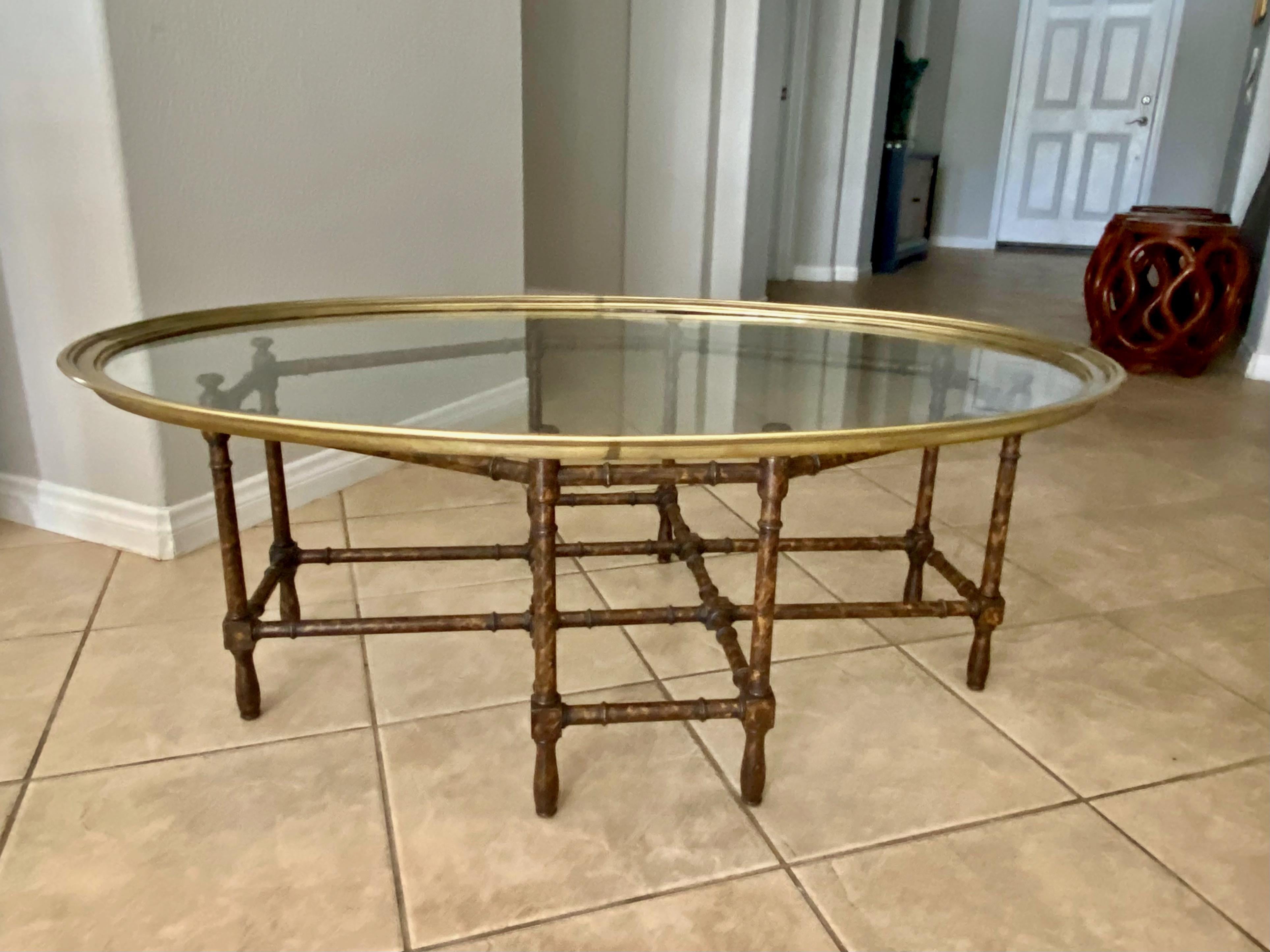 Oval brass and glass inset top coffee table resting on faux bamboo wood with faux tortoise shell lacquered finish base. The removable oval brass edged glass top is solid and heavy. Octagonal base features brass caps on the eight legs.