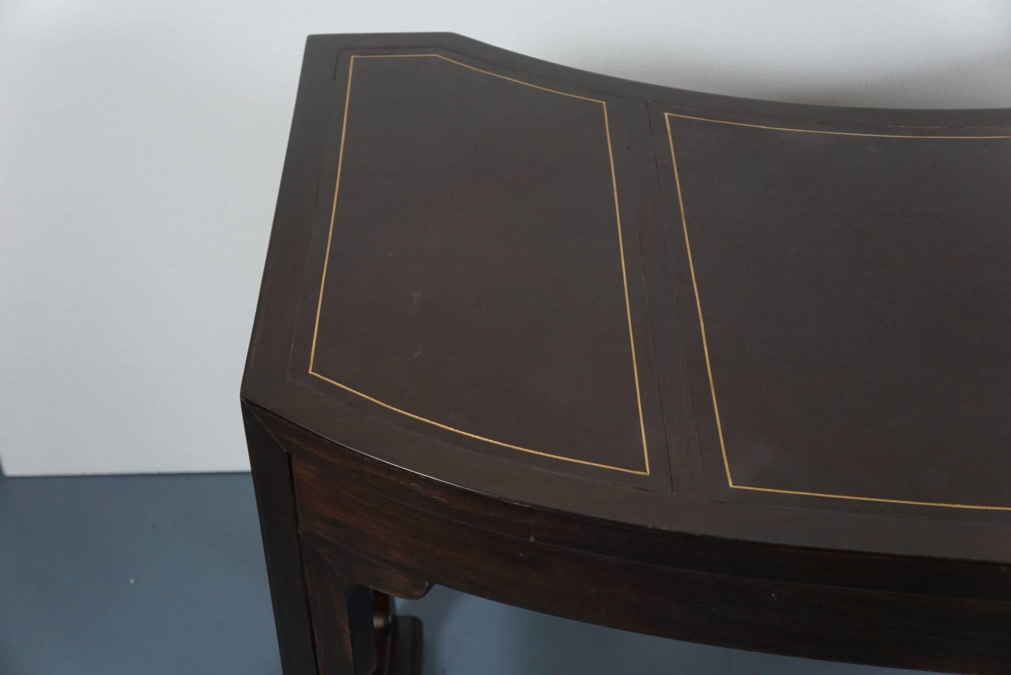 Here is a great desk in dark walnut with a leather top by Baker Furniture. The desk has a French 1940s Moderne aesthetic with its curvaceous lines. There is a centre pull-out drawer.