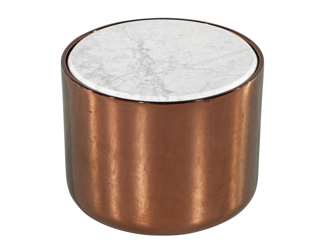 This stunning piece features simplistic yet sophisticated styling, with sleek clean lines that will effortlessly elevate any room. The light bronze metal finish adds a touch of elegance, while the white and grey veining on the round marble top