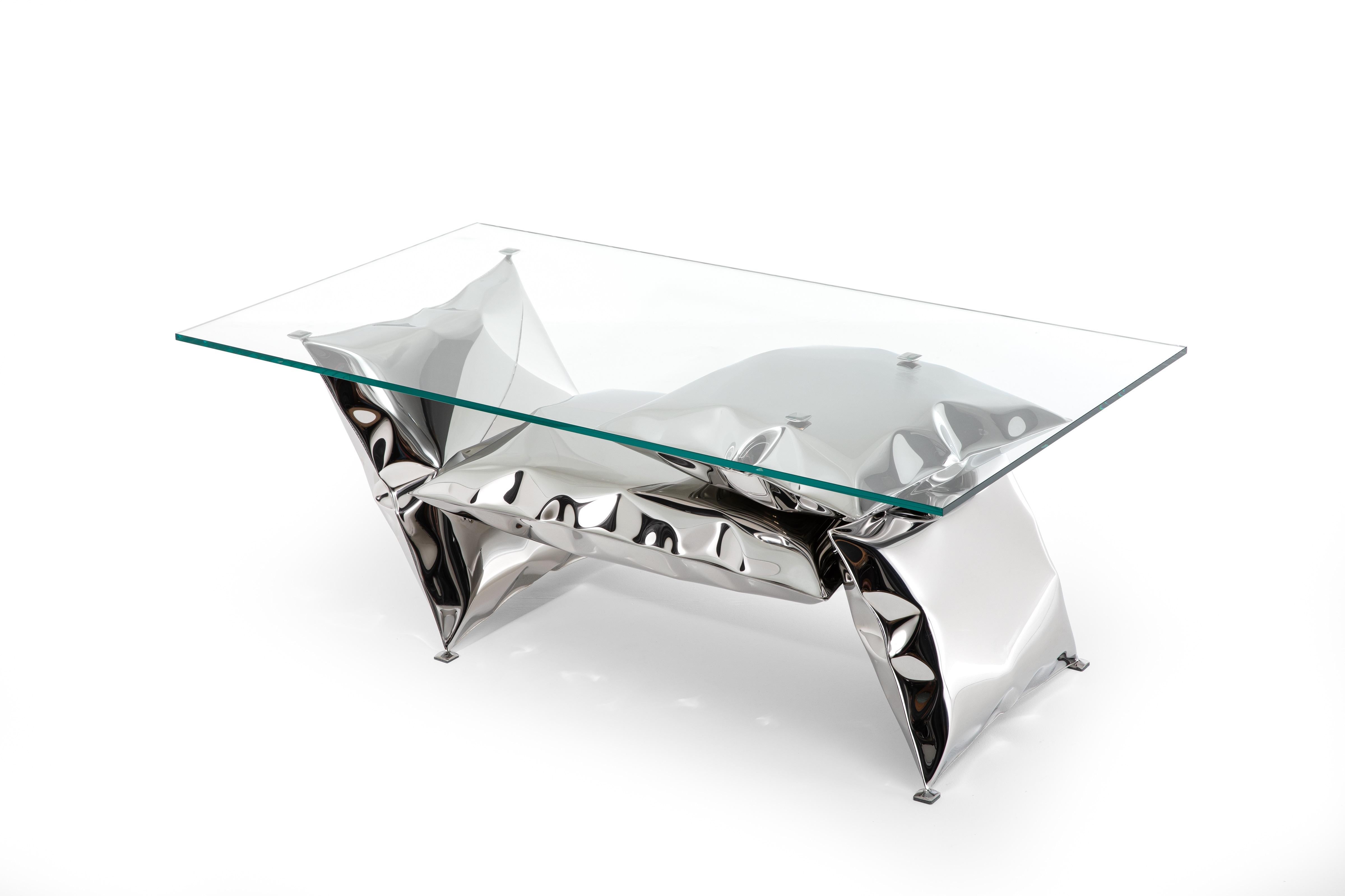 Inflated metal coffee table. Highly mirror polished stainless steel and 10mm toughened glass with polished edges. 
Each table is hand made, numbered and signed in the UK with each table differing from the previous. All welds are blended and polished