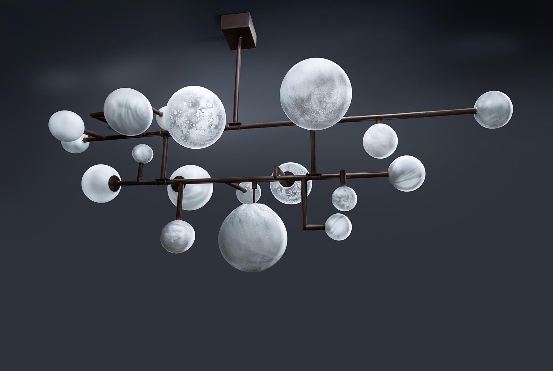 Balanced planets chandelier by Ludovic Clément d'Armont.
Materials: brass, blown glass, LEDs.
Dimensions: W 232 x D 82 x H 112 cm.

The chandelier balances itself, hanging at one hook only. Large glassware can even be held by their