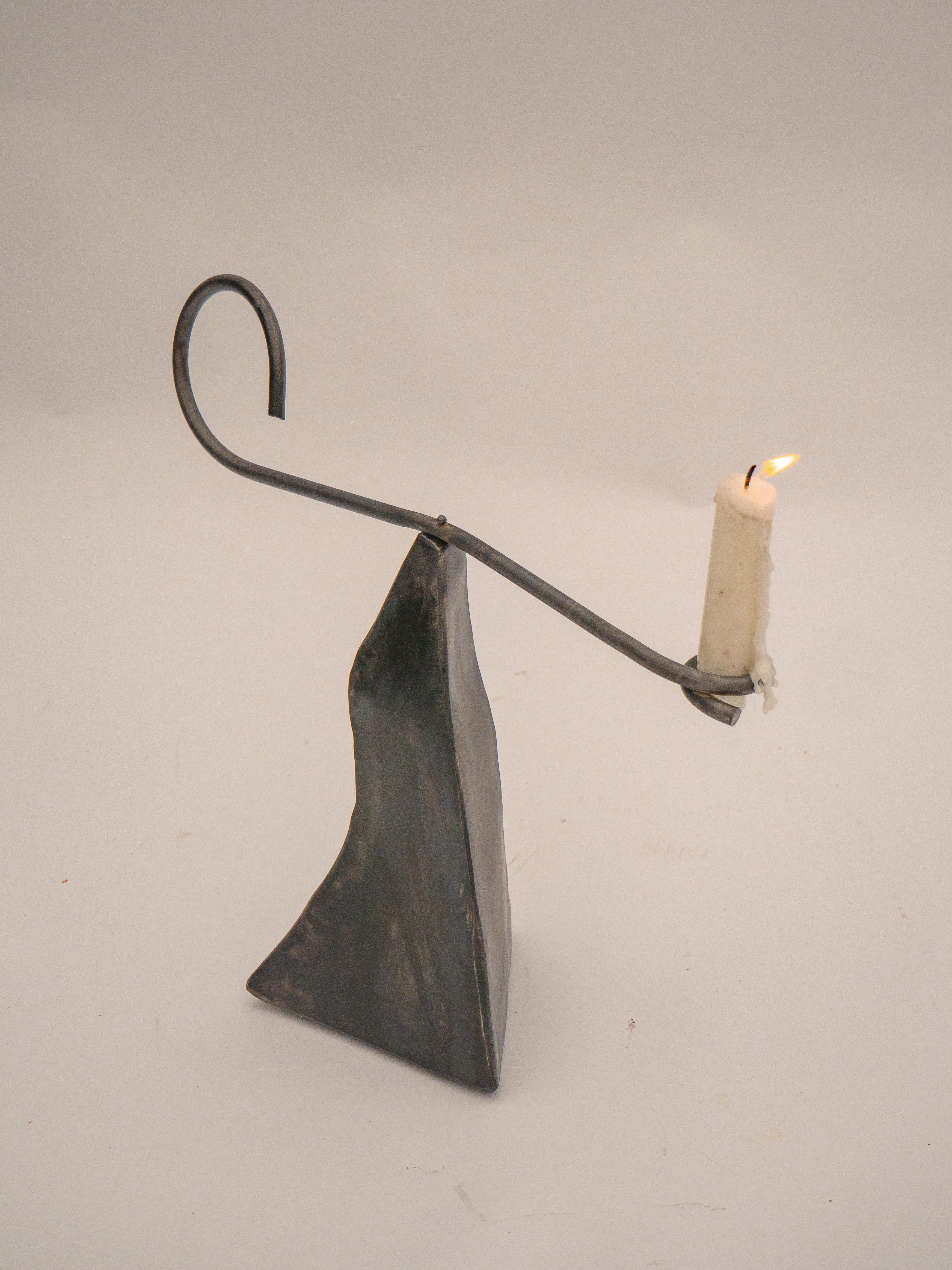A welded Steel Candle holder. Balancing Act is a collection of two lamps and a candle holder. Inspired by Calder’s Circus, it captures a sense of naive joy and playful freedom, inviting interaction and spontaneity through balanced forms and